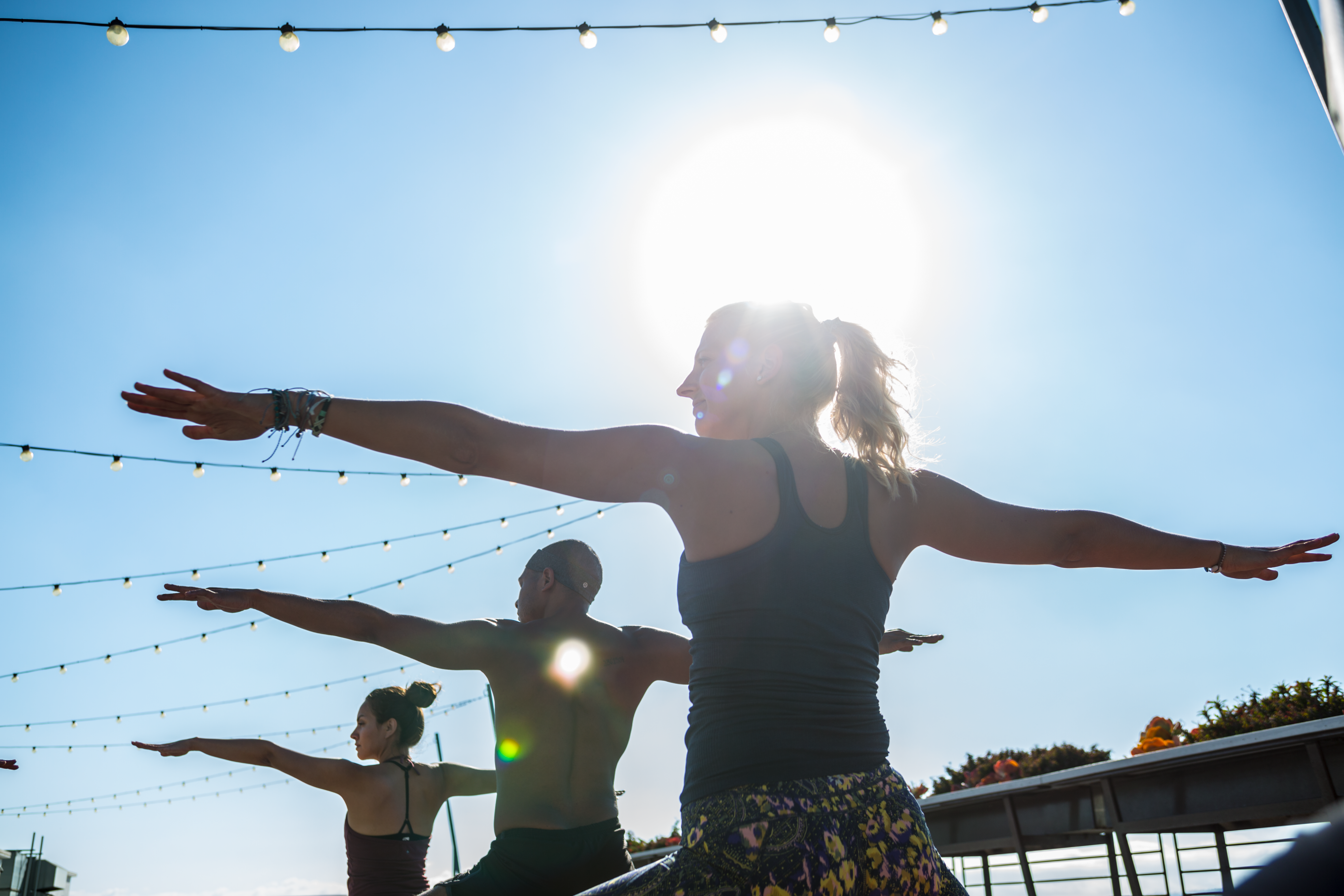 Tres personas practicando yoga a cielo abierto