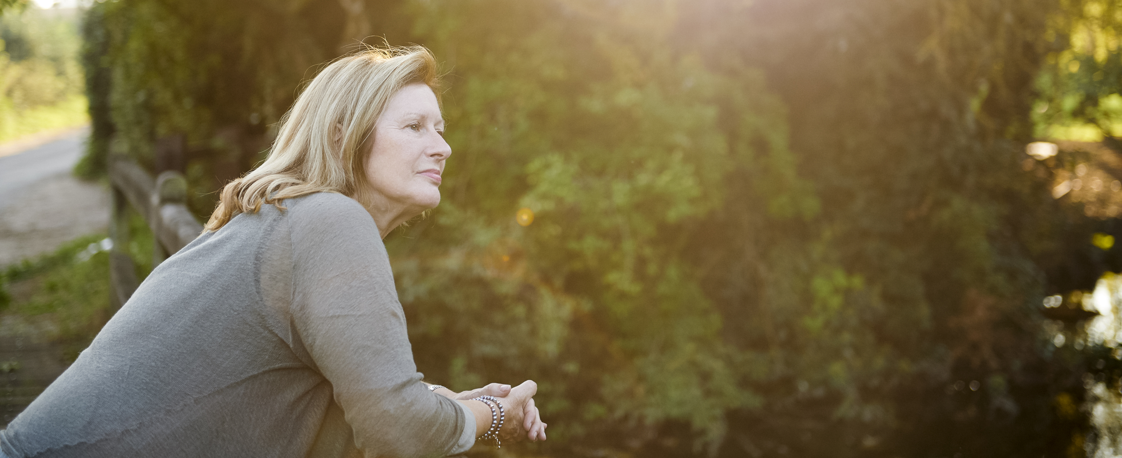 An Airbnb host looks out onto her yard during sunset.