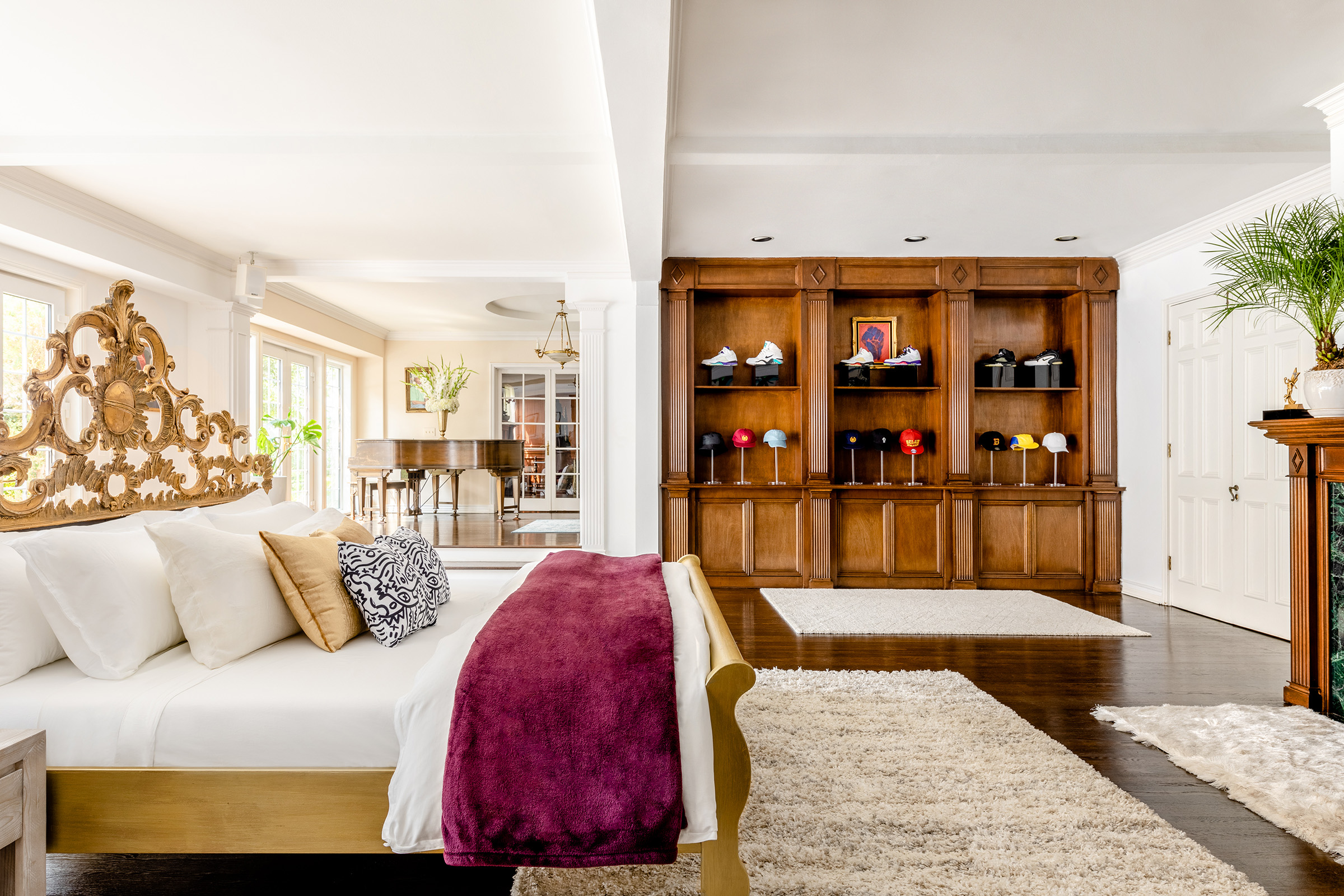 A wall covered in special Nike sneakers is visible behind a luxurious bed.