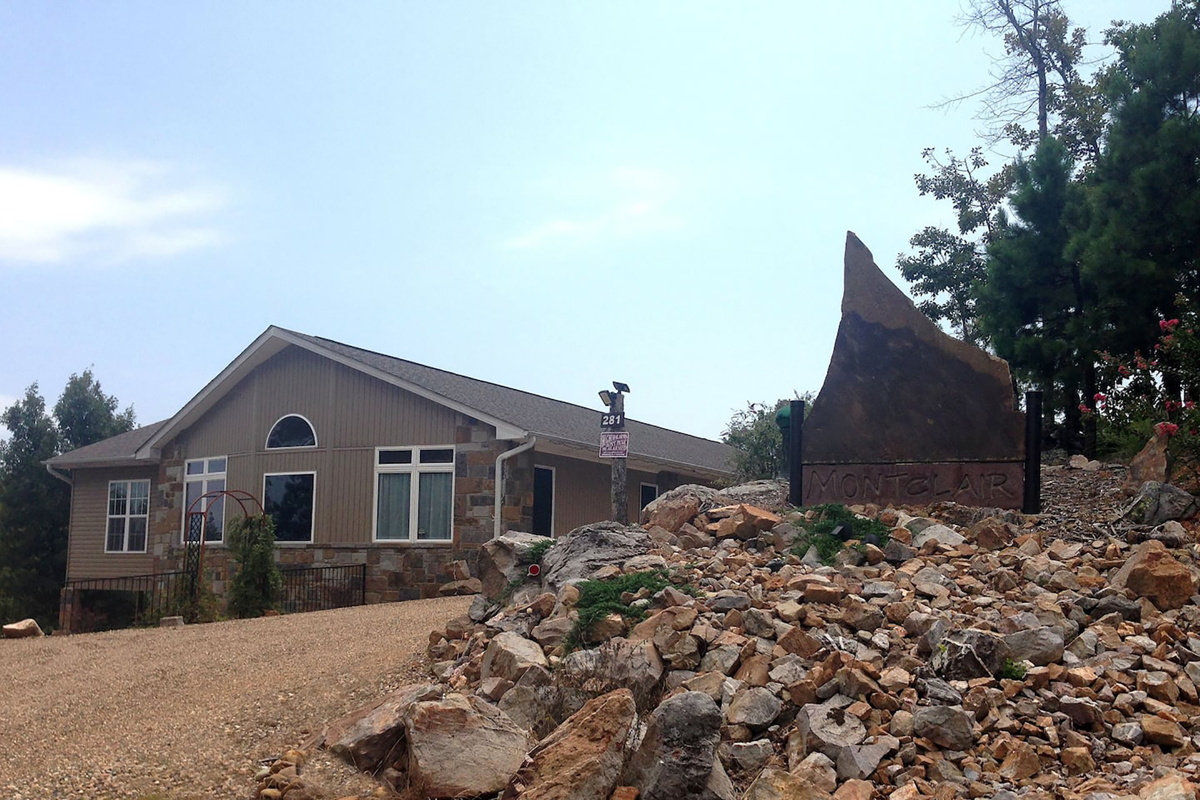 A sign in front of a brown and stone home which reads "Montclair"