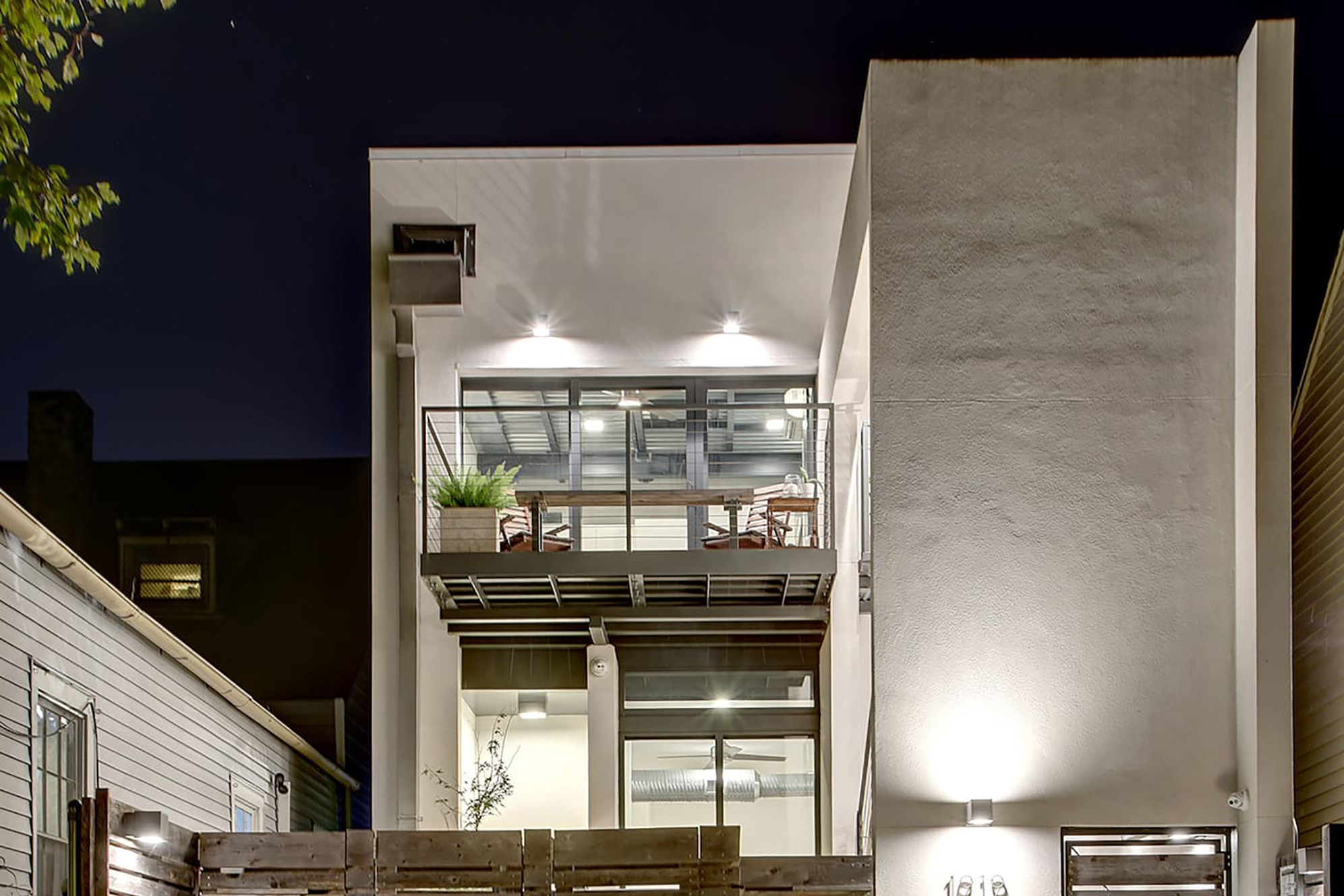 A modern, two story home with a balcony.