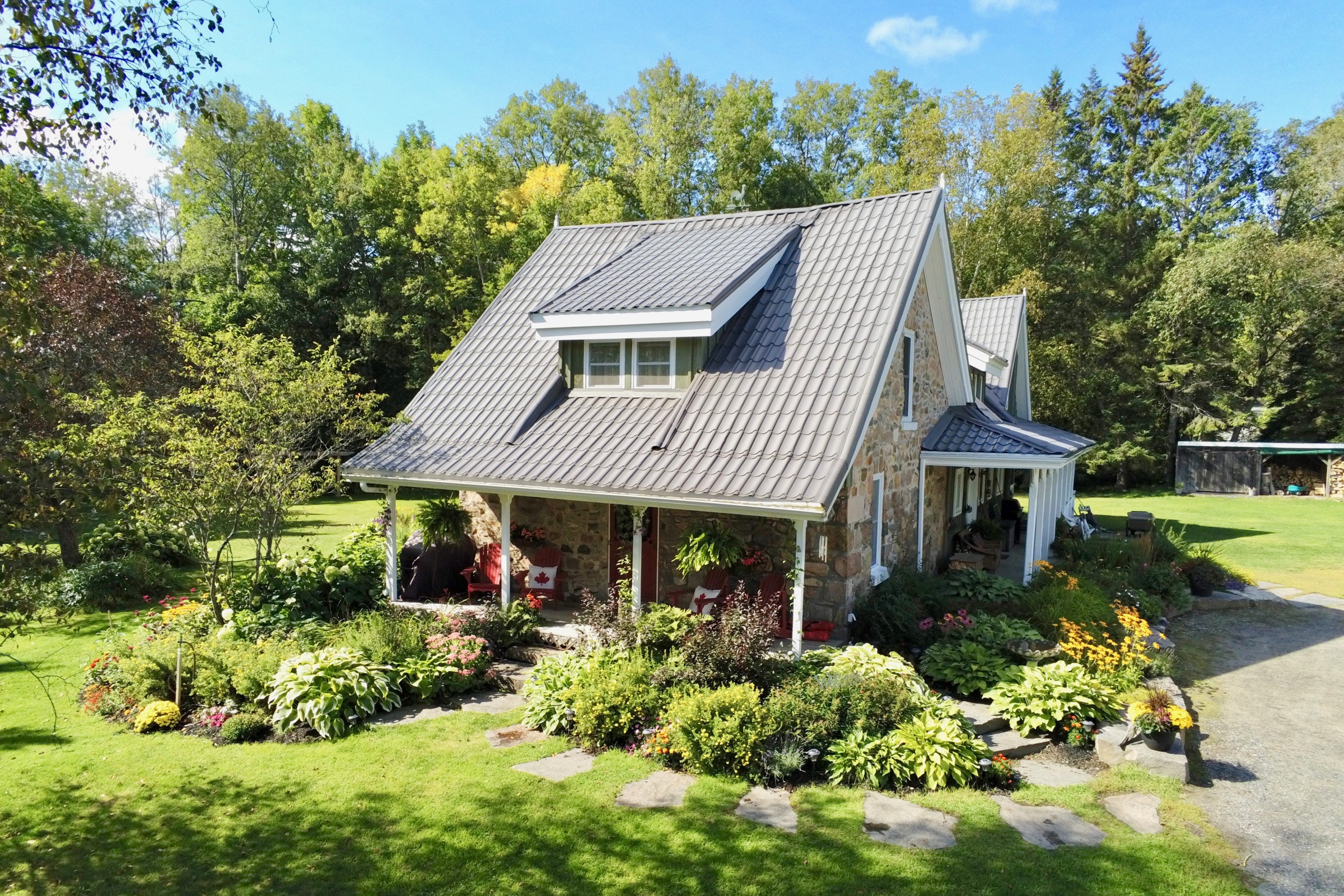 Stone house with walkway to the front door surrounded by flowers