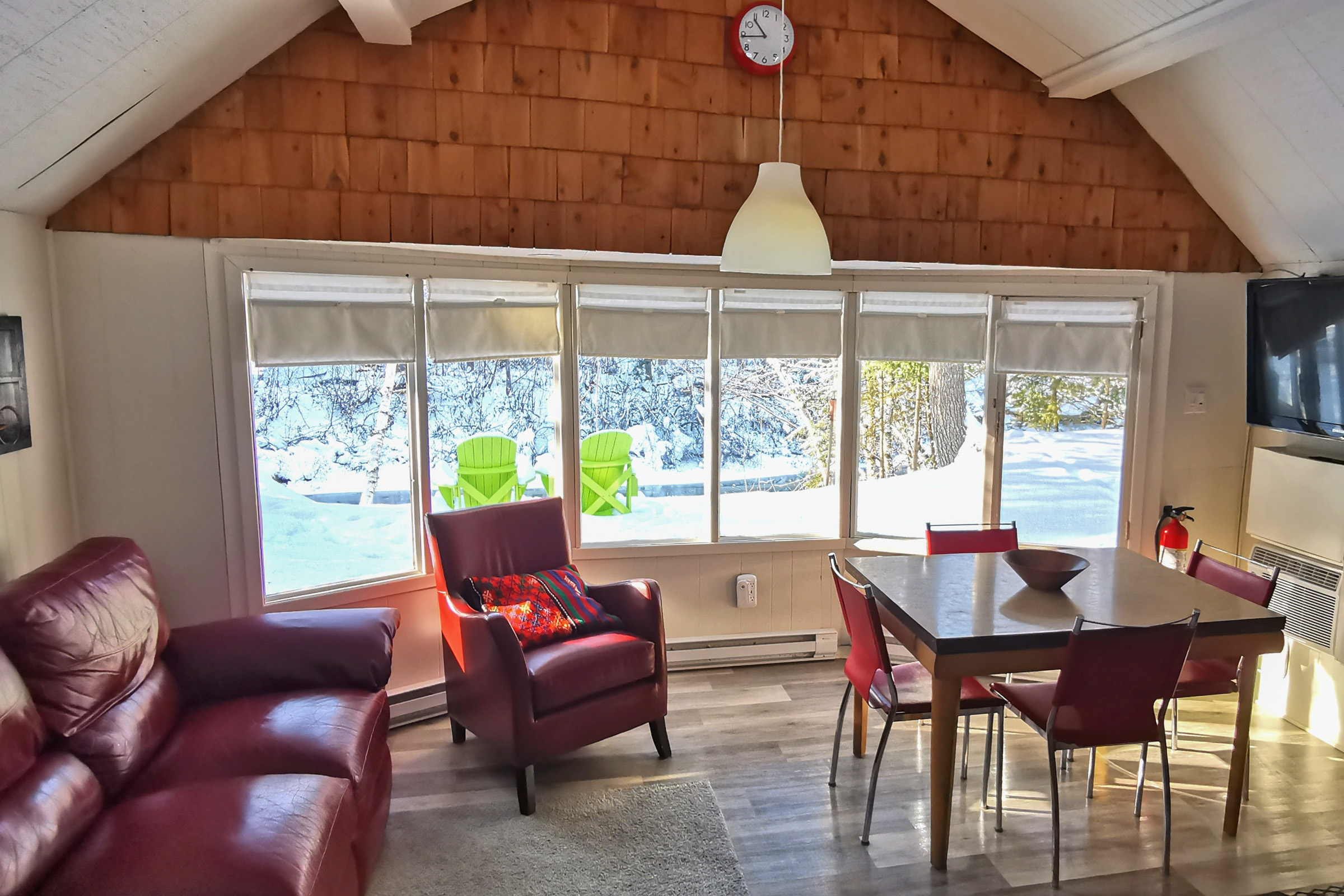 Living room with red leather couch and chair overlooking a snowy backdrop