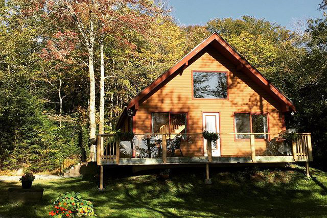 A-frame chalet with brown siding and a front porch