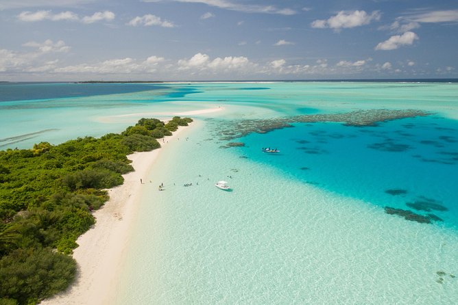 Portion of an island beach surrounded by clear blue water