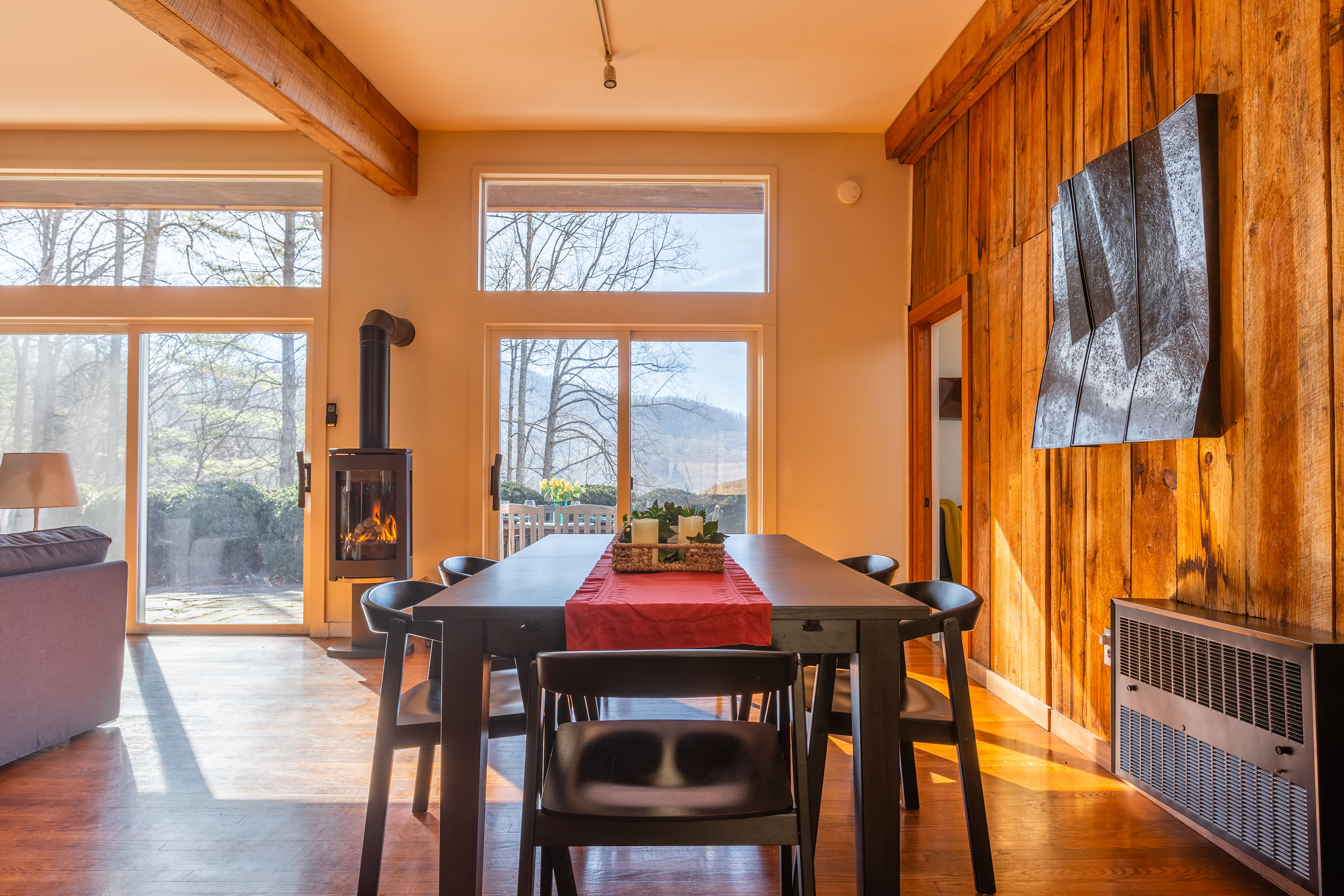 Kitchen table inside of a cabin, with a view overlooking a forrest