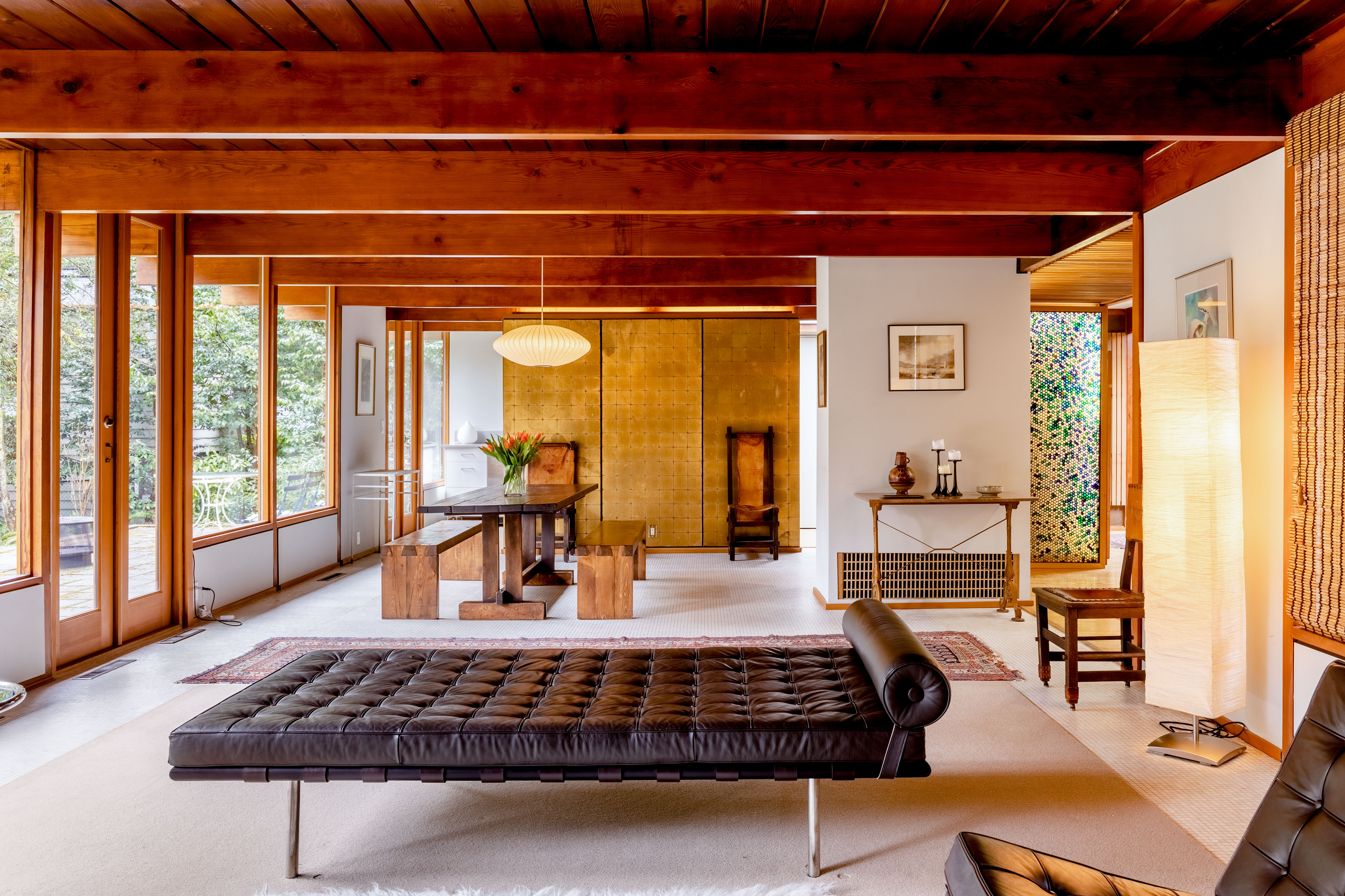 Modern living room with a large, black chaise lounge at the center.