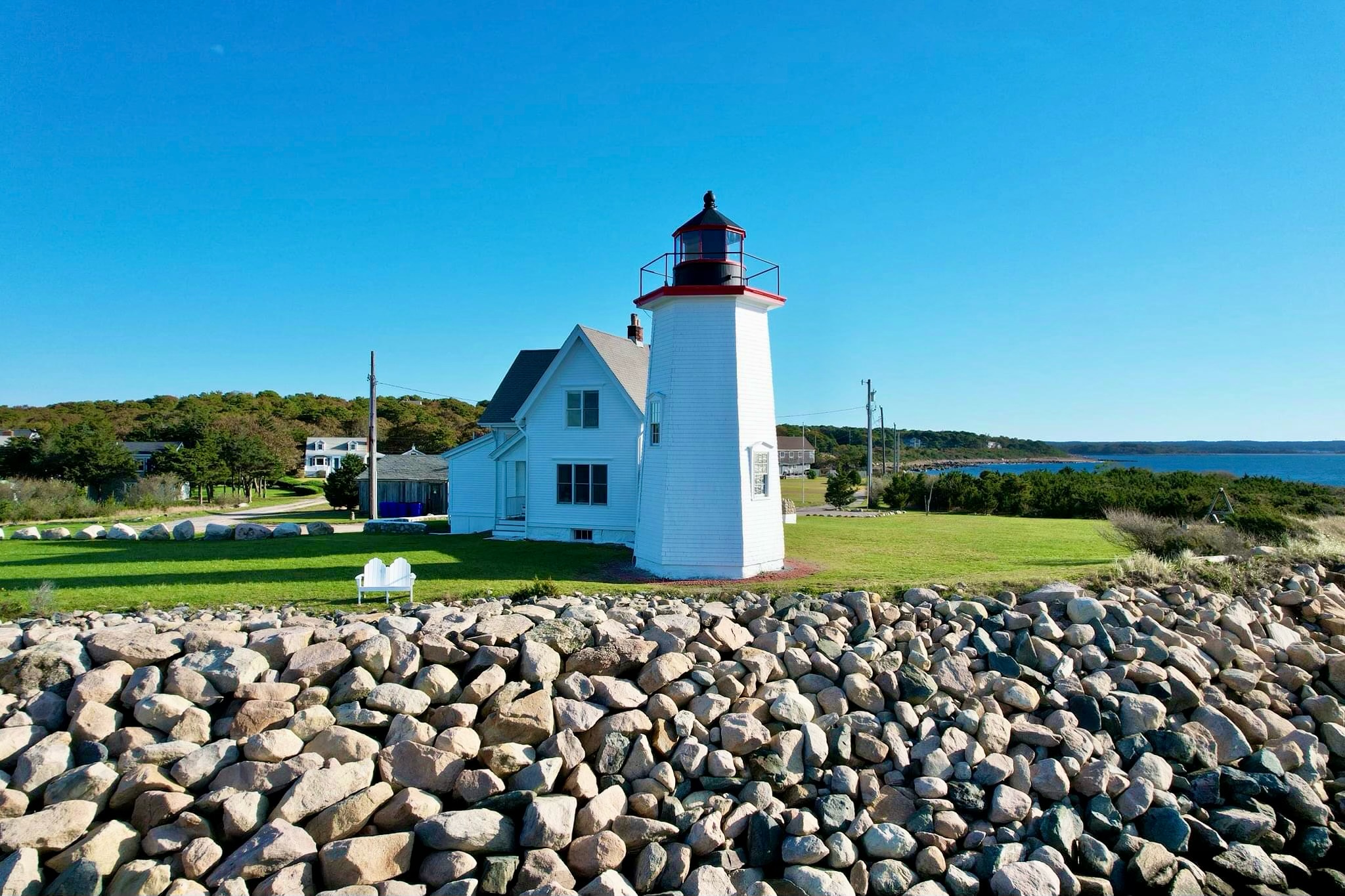 A white lighthouse on a rocky coast.