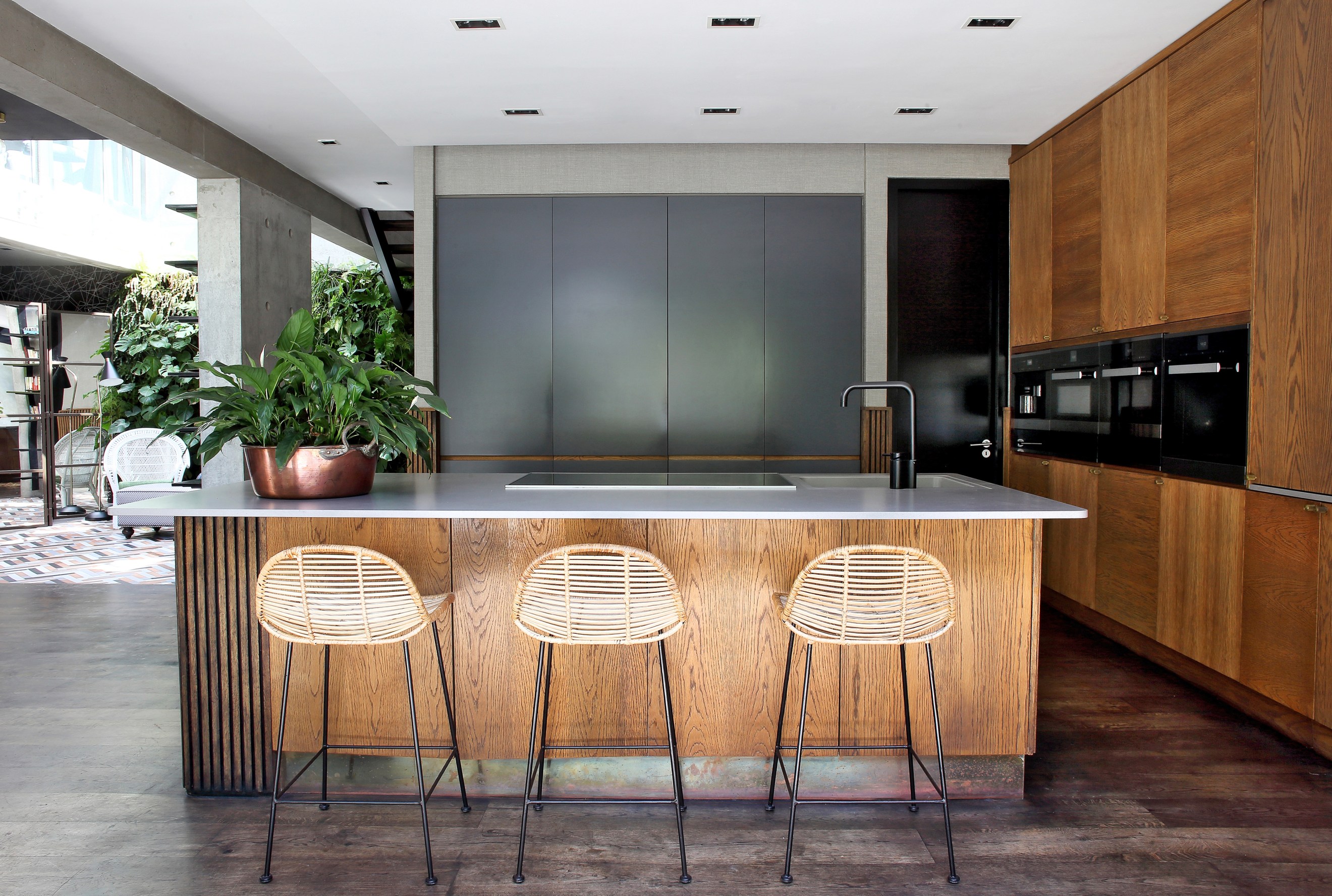 Open kitchen with bar stools and modern all-wood cabinetry and island touches.