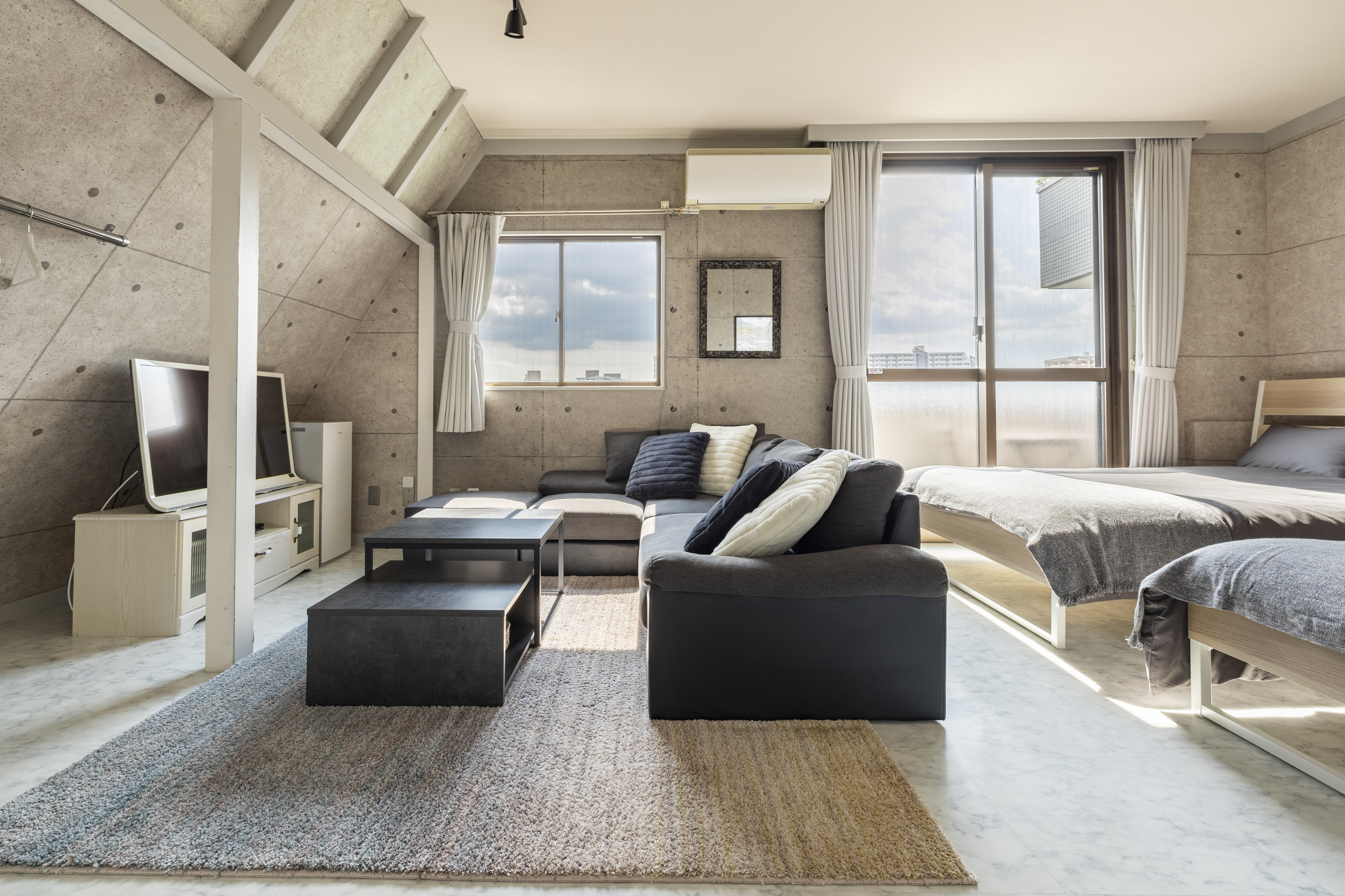 A gray bedroom and living room with blue accents