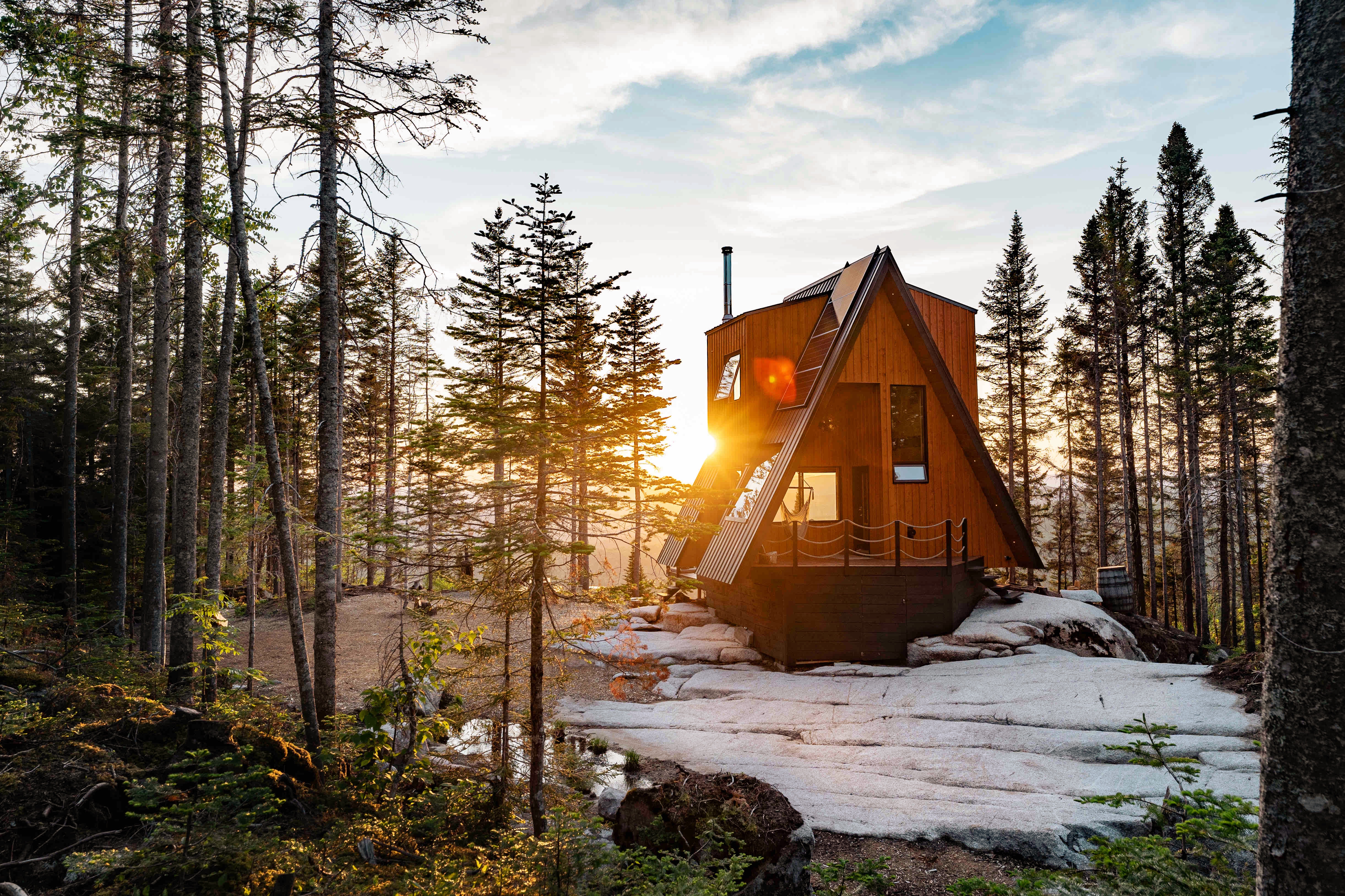 A sunrise over a cabin in Quebec near the woods