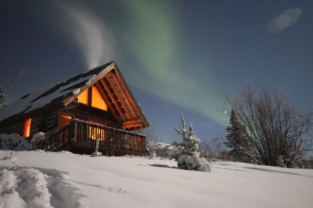 The northern lights on an A-frame in winter.