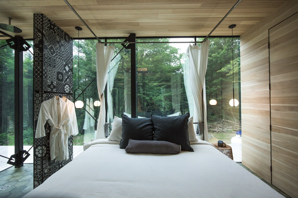 An open concept bedroom with facing a forest.