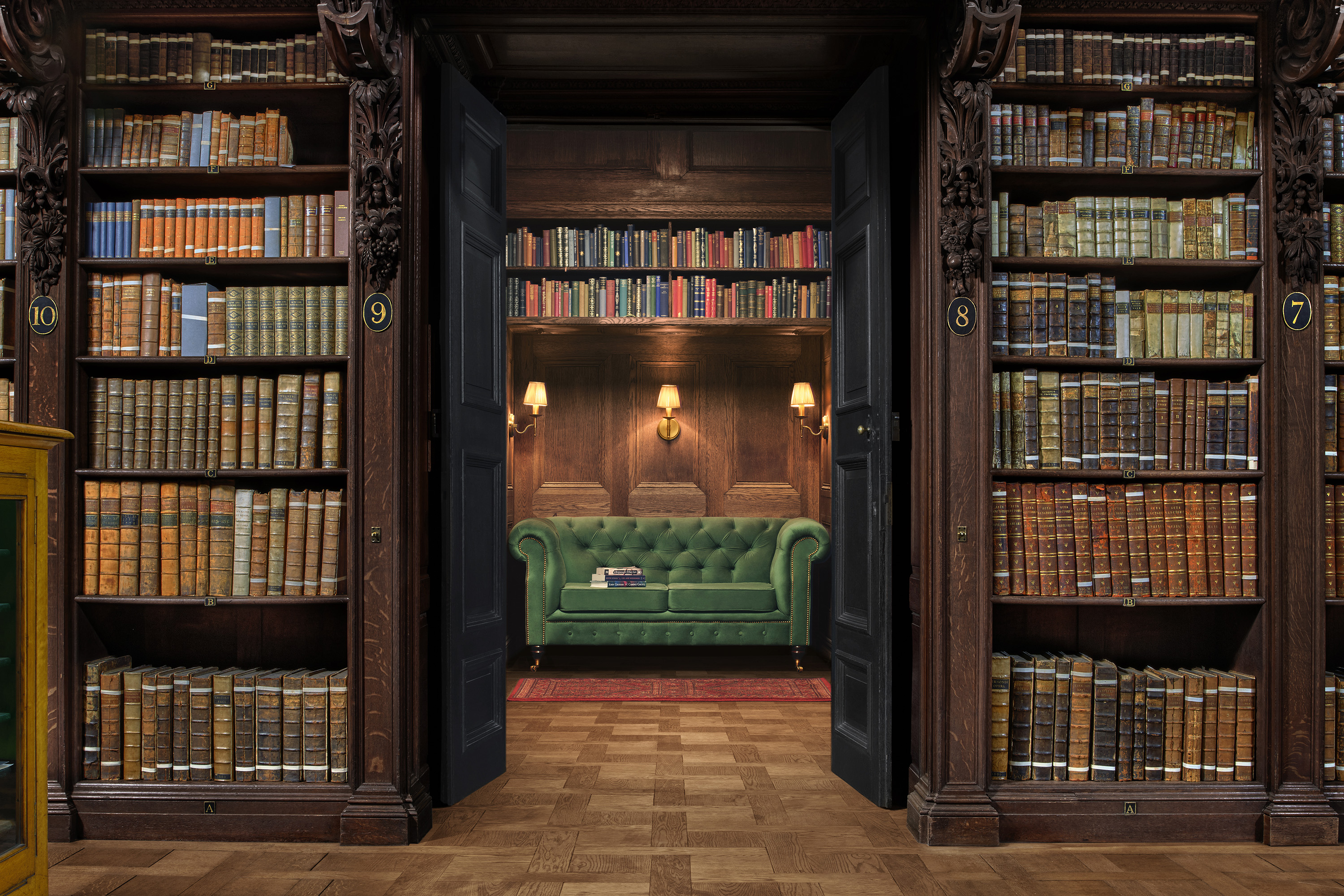 Shot of the reading room in Saint Paul's Cathedral, showing some of the historic volumes and a cosy reading nook with a green sofa.