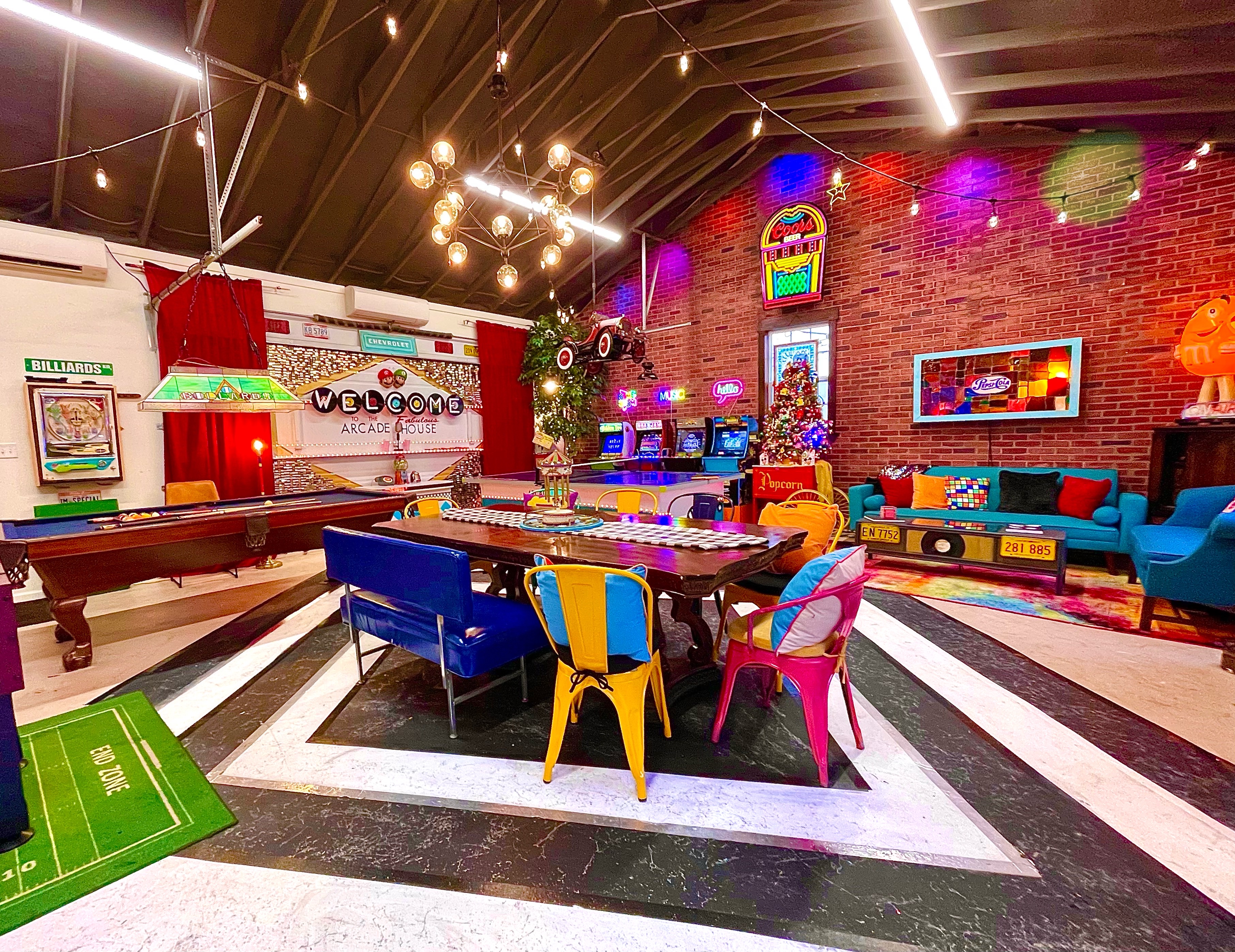 Interior shot of an 'Arcade Home', showing a brightly colored living room with a pool table and lots of gaming paraphrenalia.