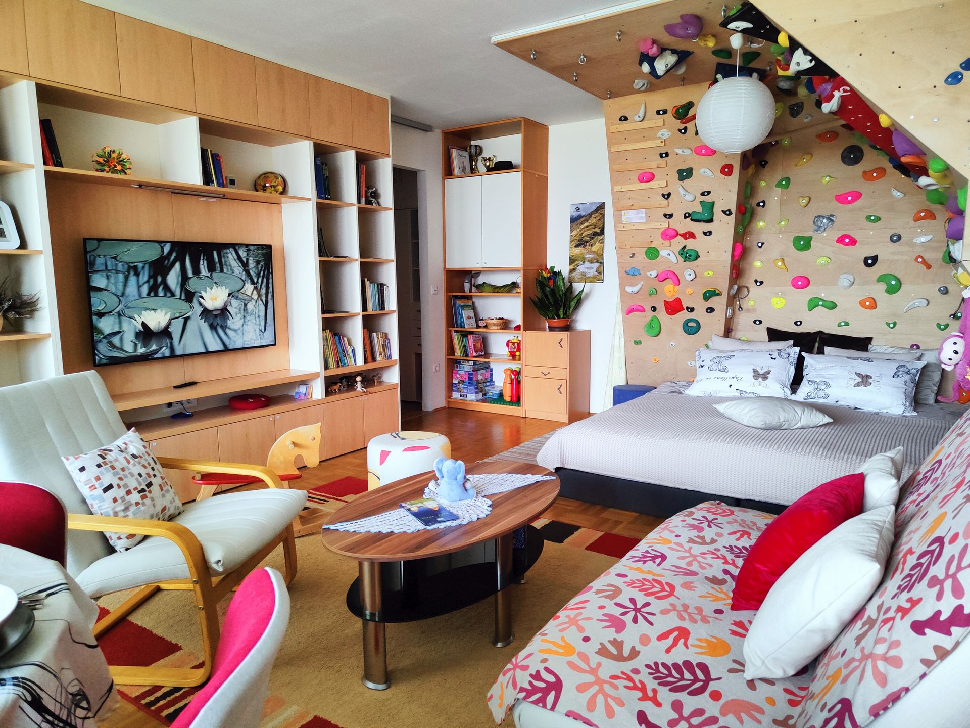 Interior shot of a cosy studio apartment with a unique climbing wall behind the bed.