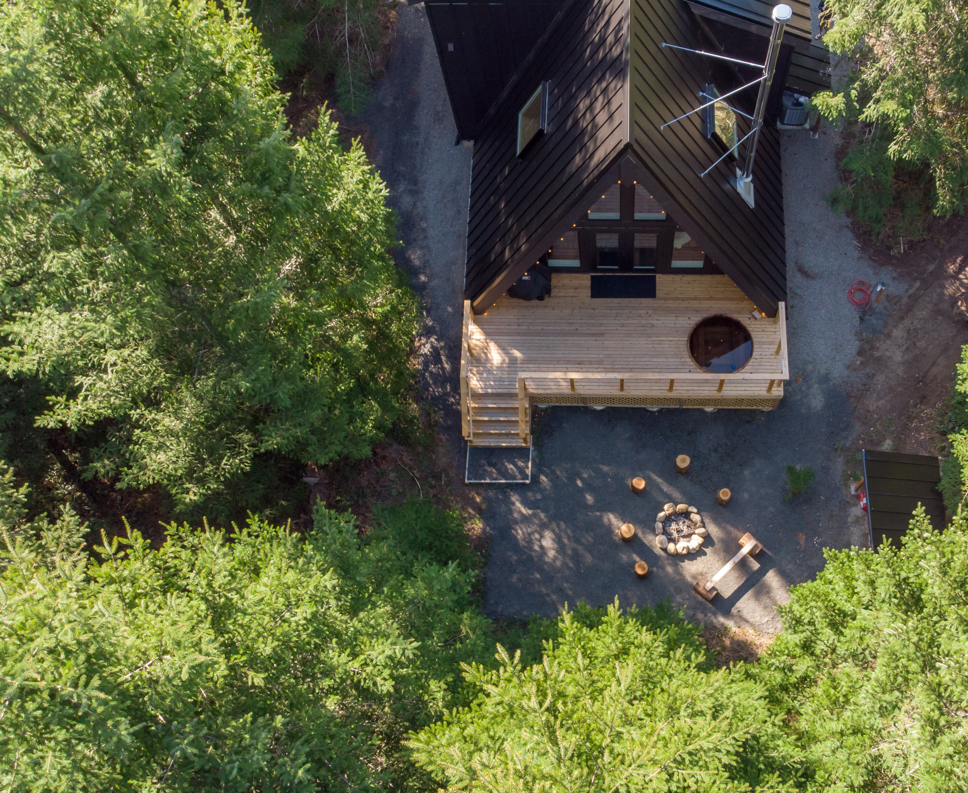Aerial view of A-frame cabin in a woodland setting