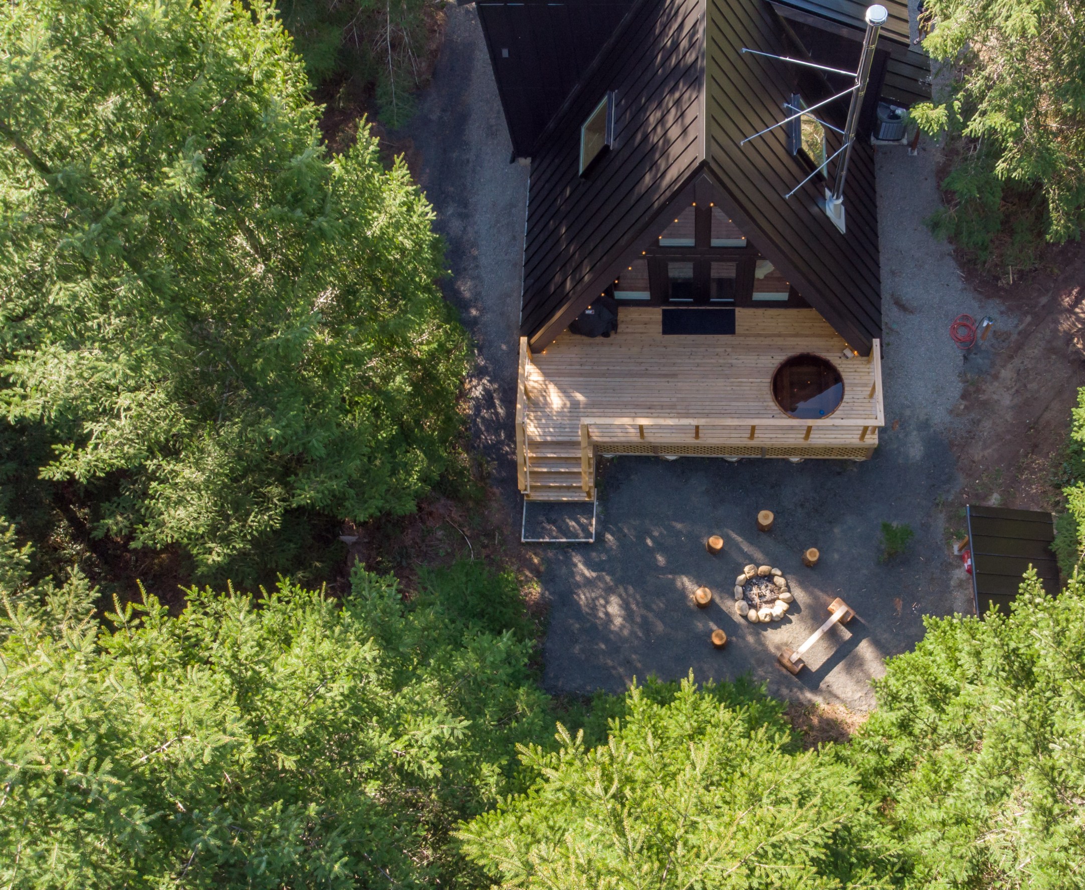 Aerial view of A-frame cabin in a woodland setting