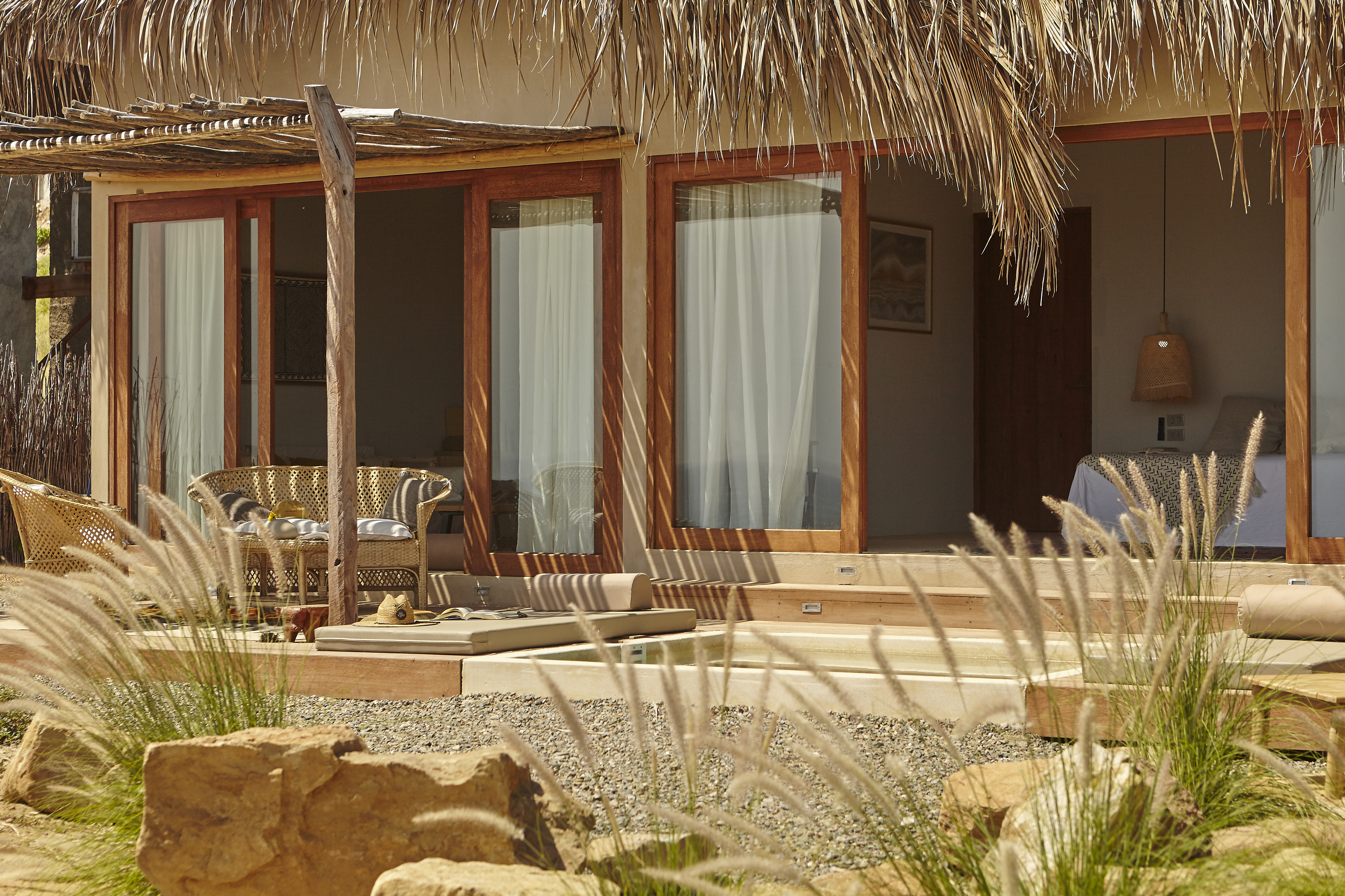 View of a house with floor to ceiling windows opened in a sunny day in Punta Veleros, Perú