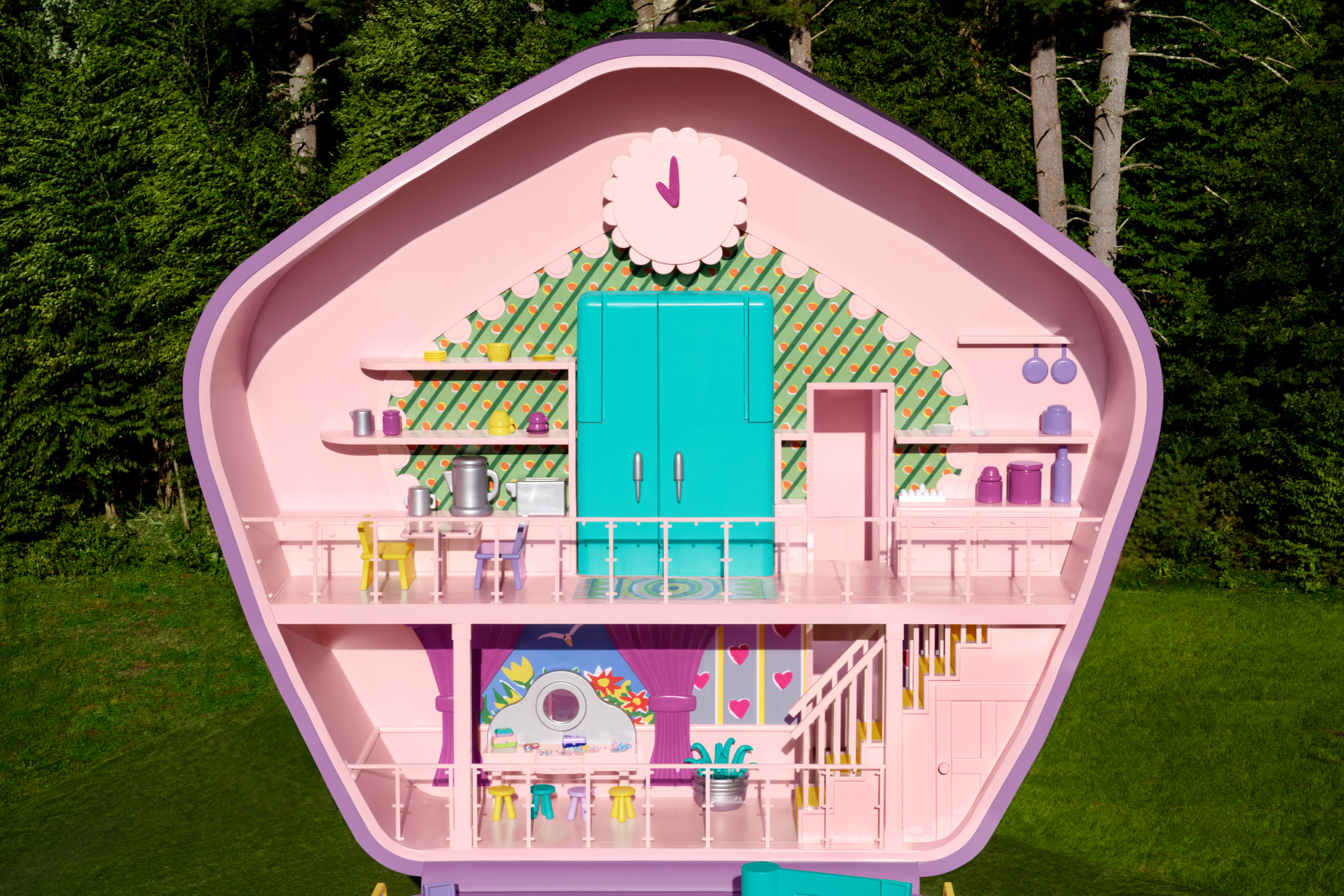 The upper level of Polly Pocket's compact includes a room with a vanity with 4 stools and stairs leading up to a kitchen.