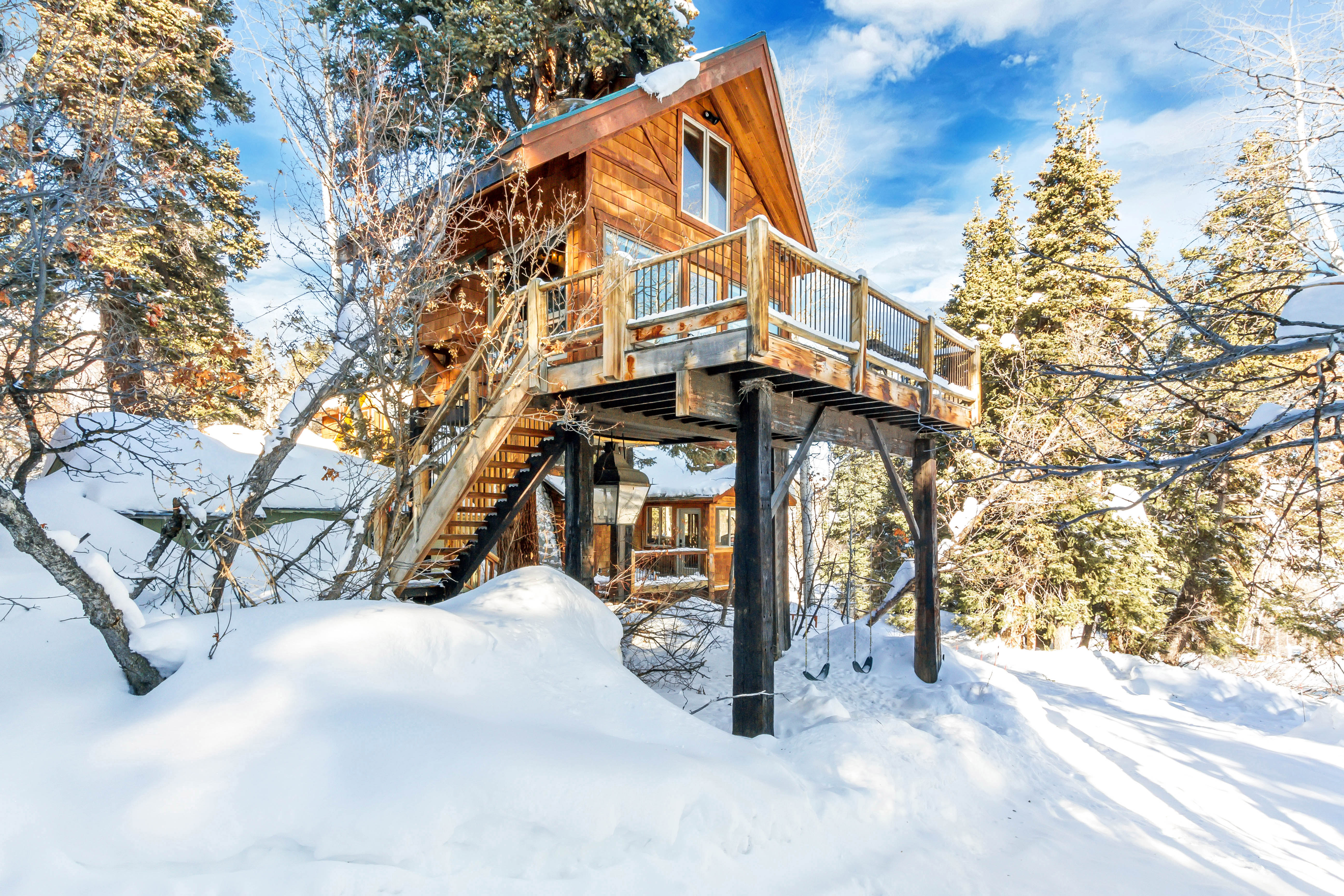 Exterior of a treehouse covered in snow