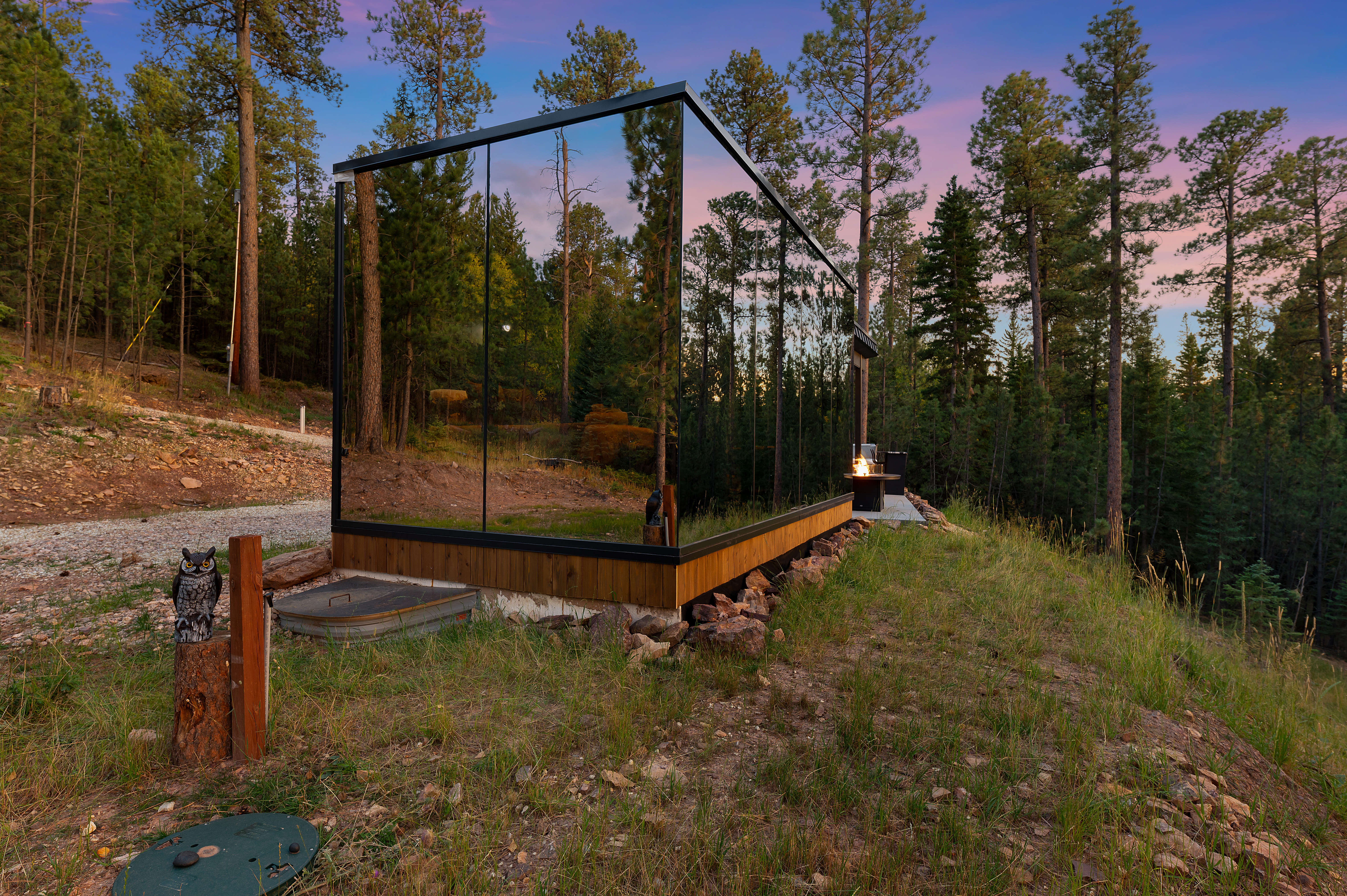A cabin covered in mirrors in the forest