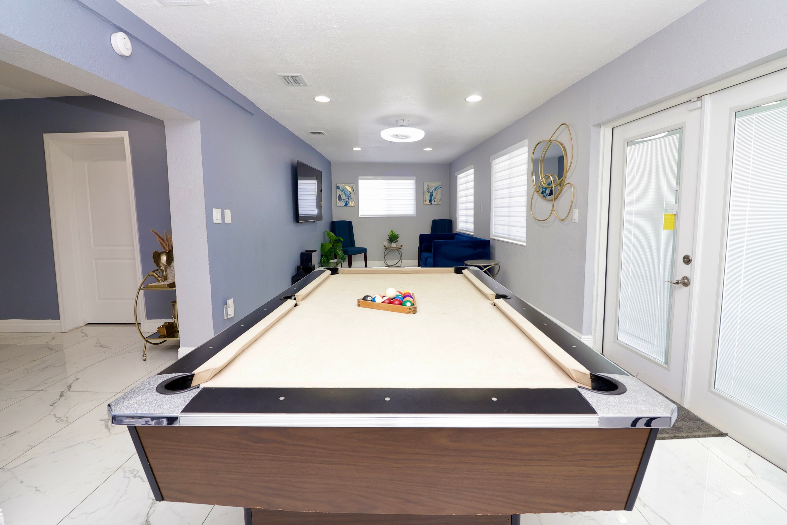 Spacious game room with a pool table and cozy seating area.