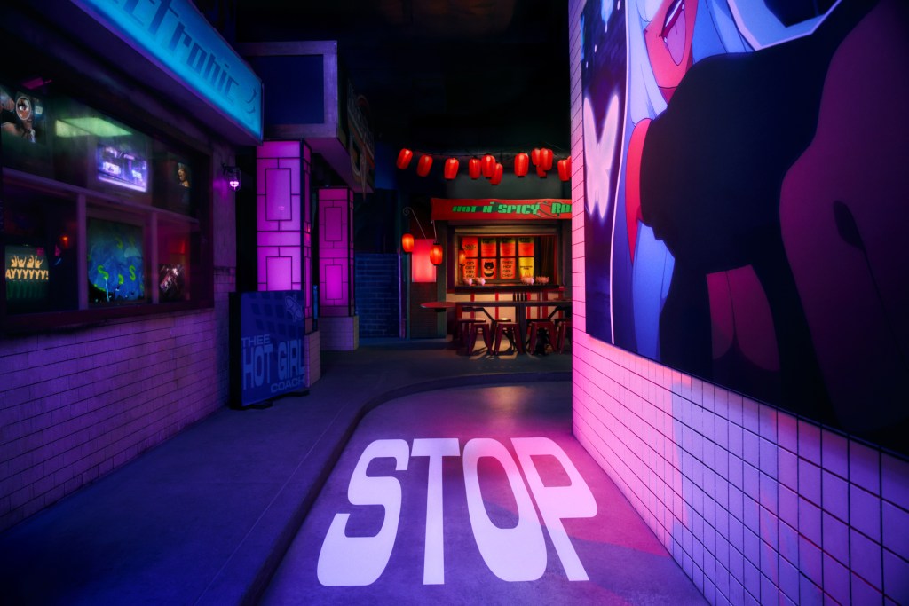 Vibrant alley with colorful neon lights, featuring a stop sign on the ground and anime artwork on the wall.
