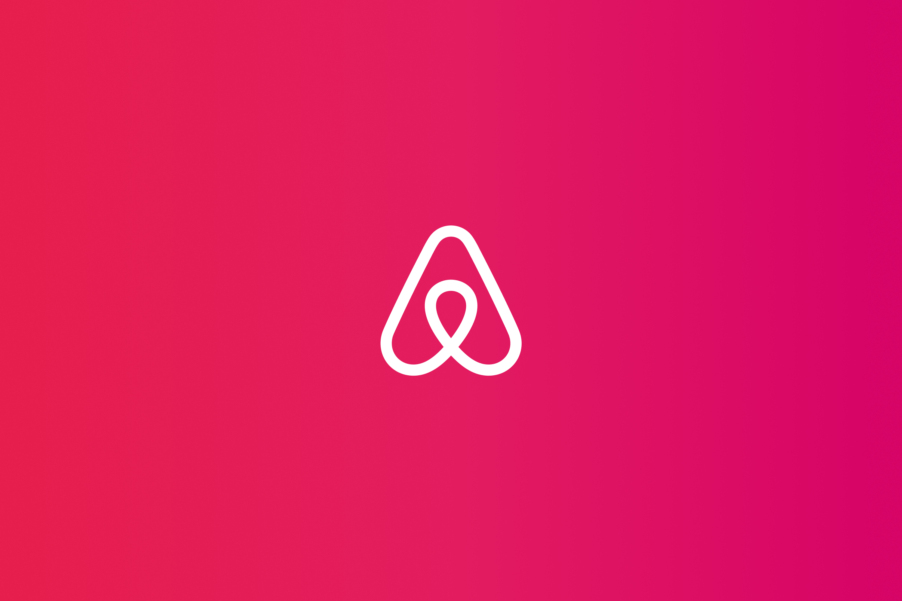 White Airbnb logo over a colorful gradient.