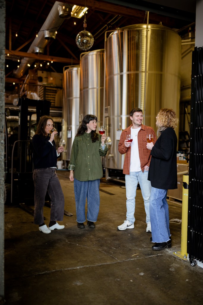 4 people standing in a brewery
