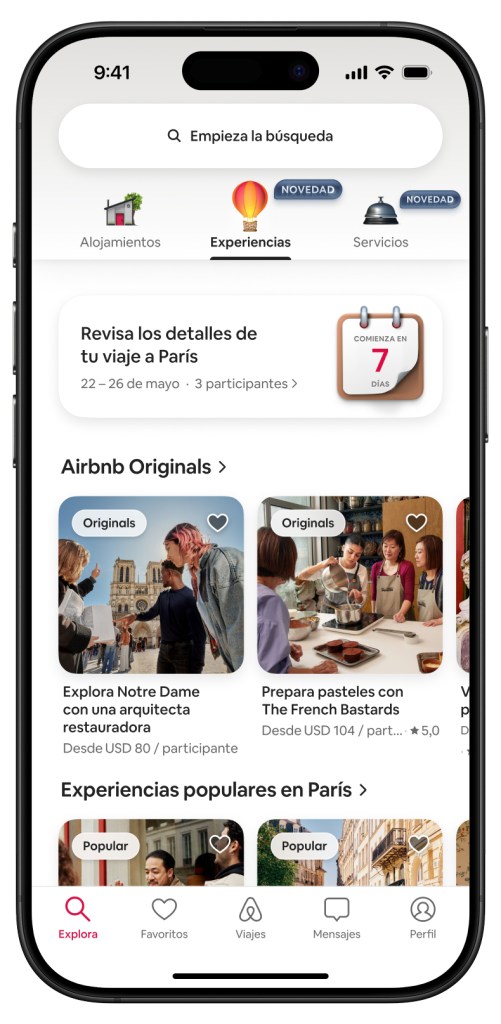 Pantalla móvil que muestra la pestaña de 'Experiencias' de Airbnb con opciones para explorar Notre Dame y hornear con The French Bastards.

