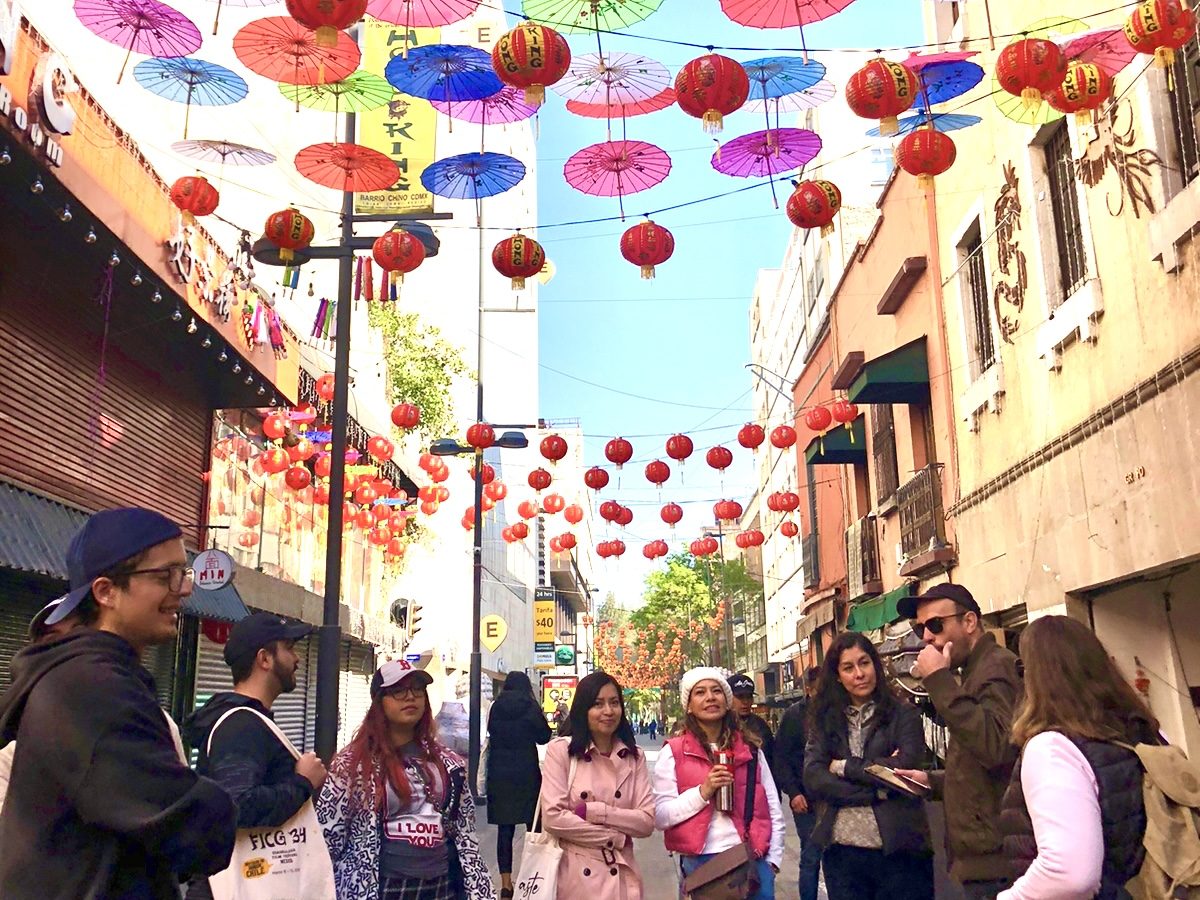 A tour group under colorful umbrellas