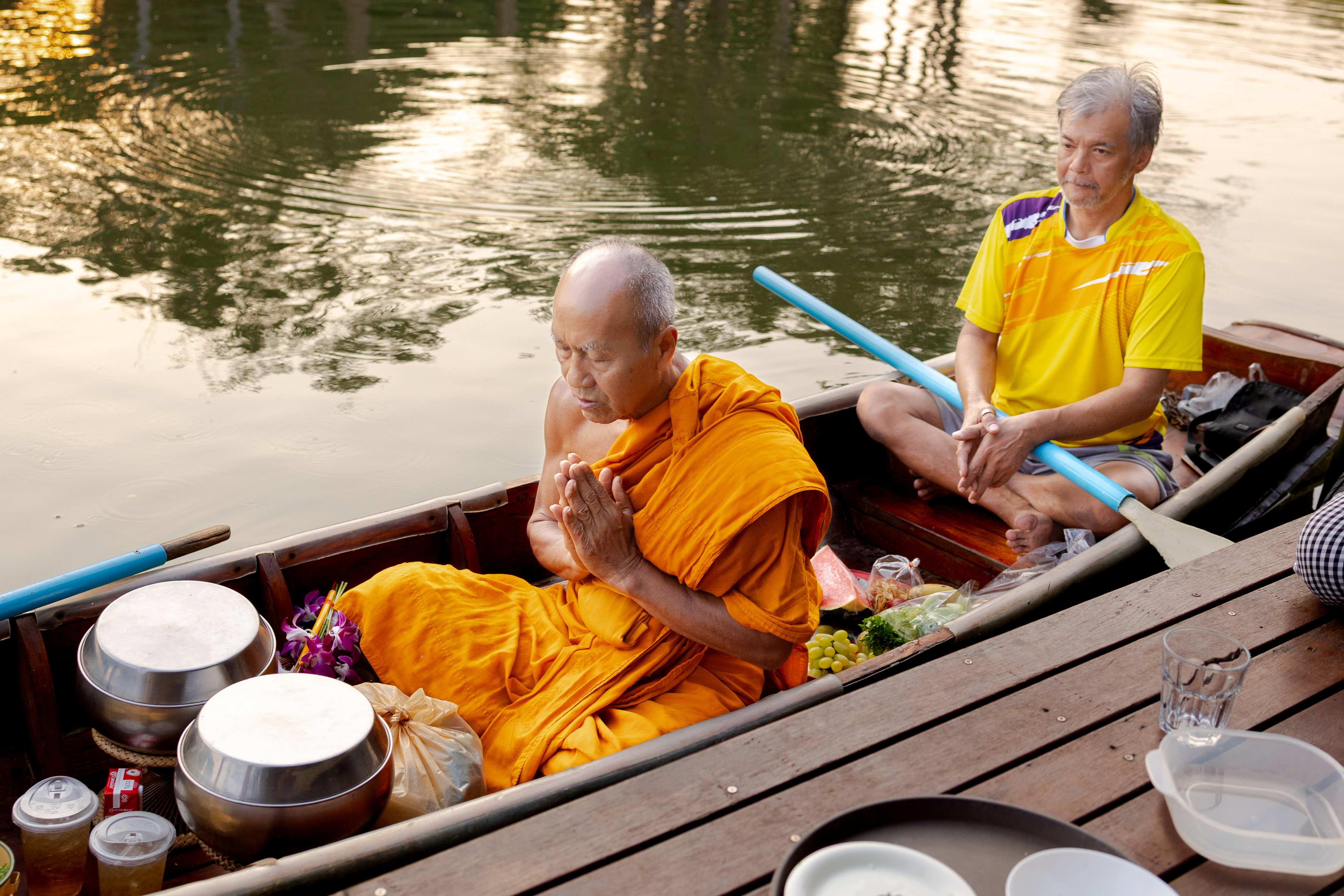 A monk and traveler in a boat in a canal