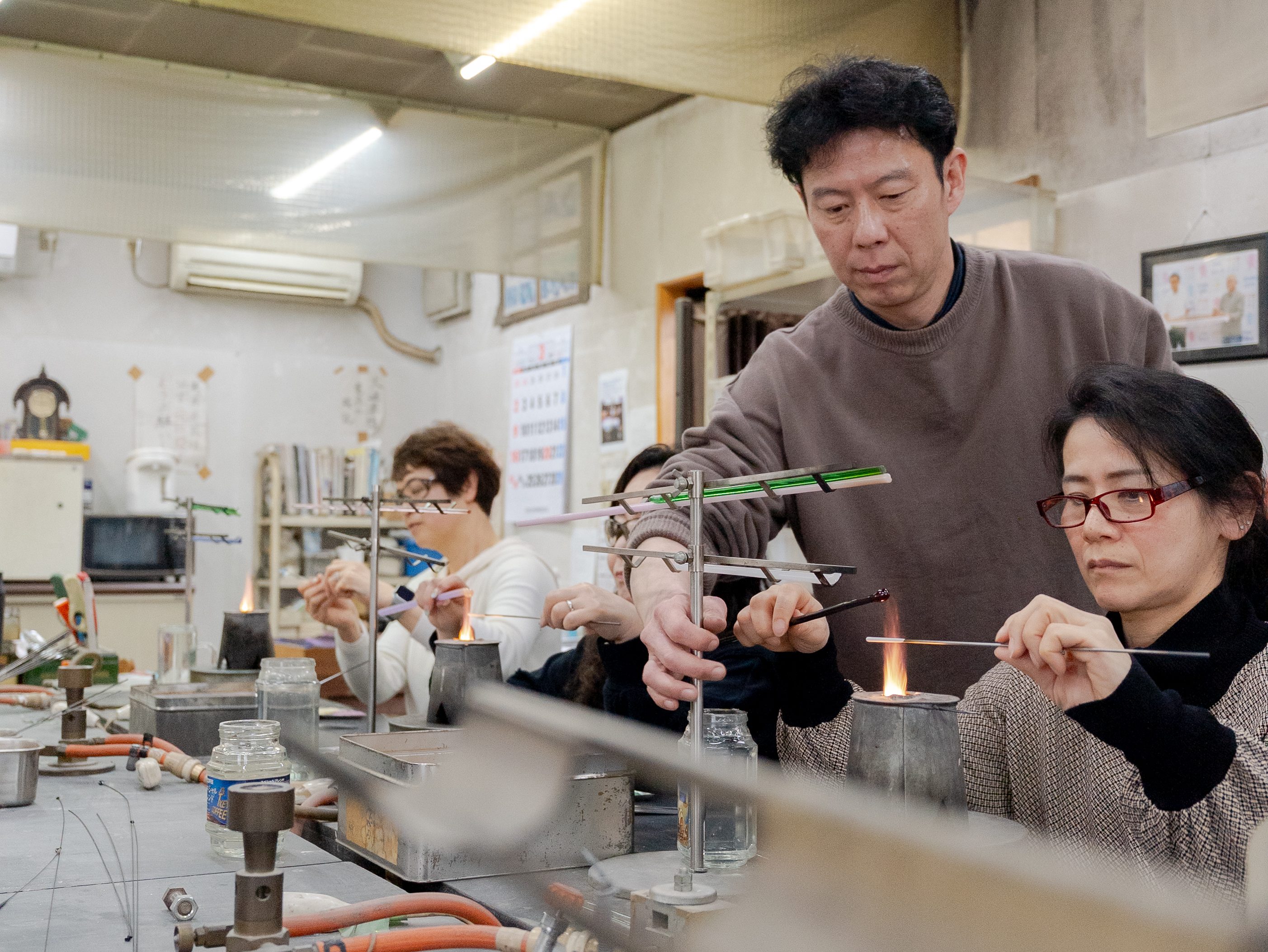 Man and woman making glass beads