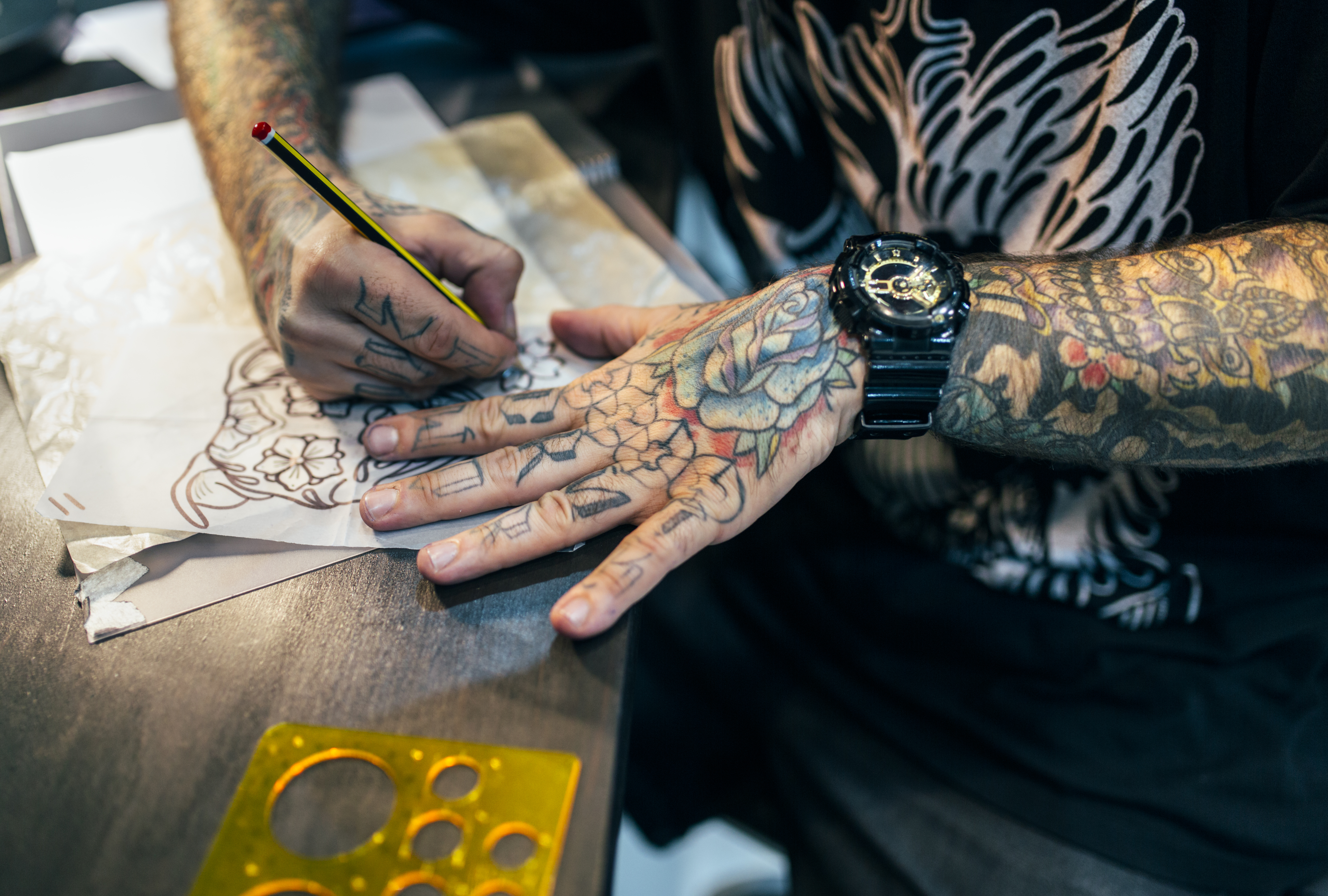 Tattoo artist sketching a tattoo stencil