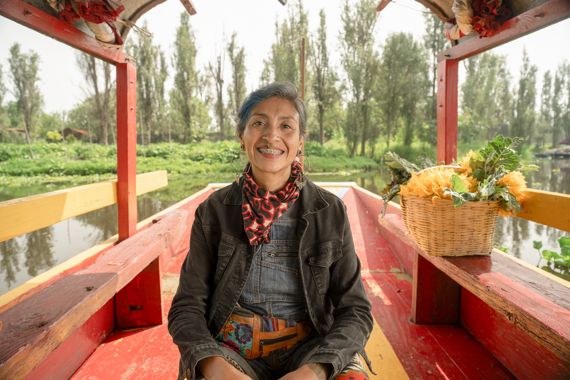 Mujer sonriendo sentada en una trajinera en Xochimilco