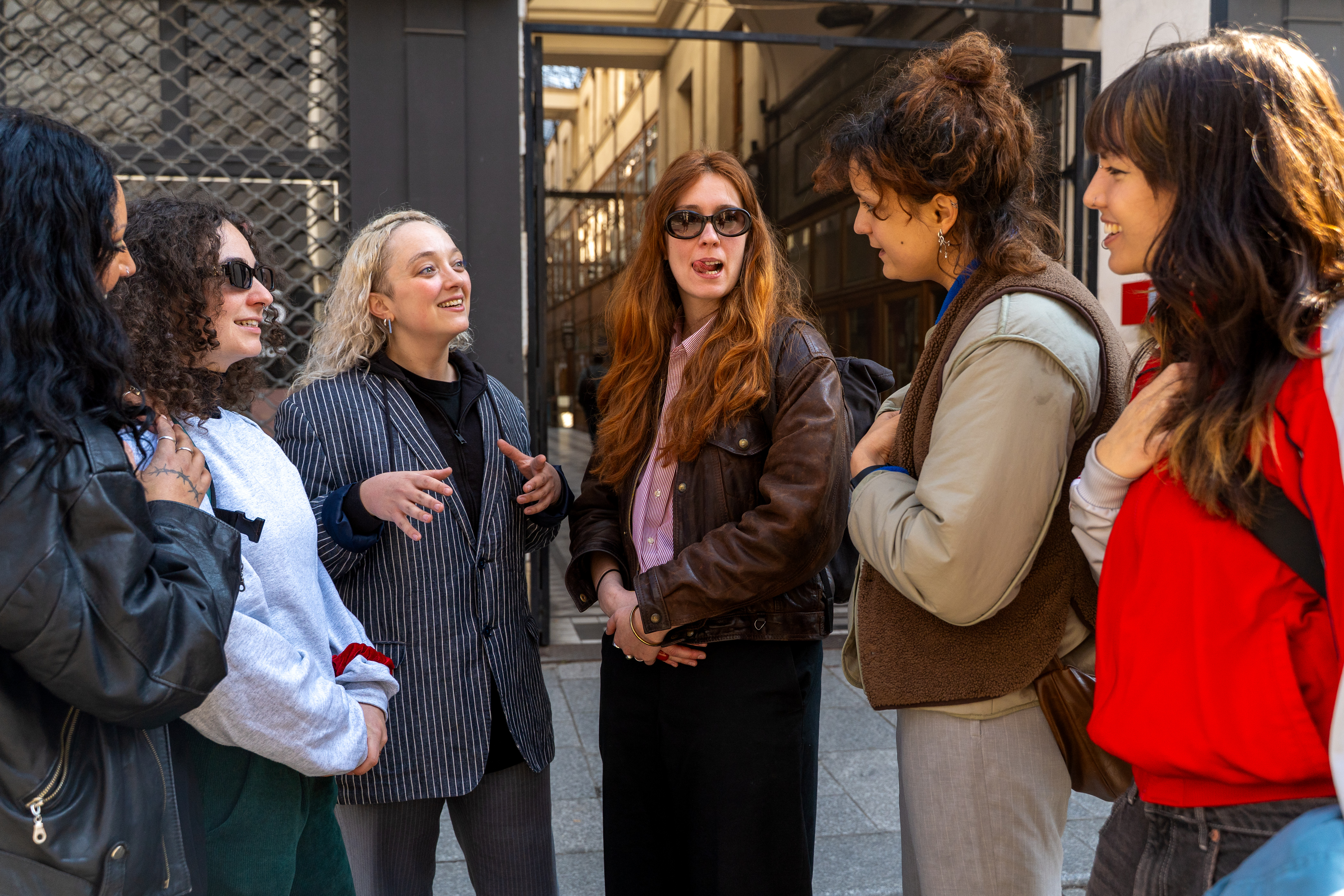 A group is having an animated conversation outdoors in an urban setting.