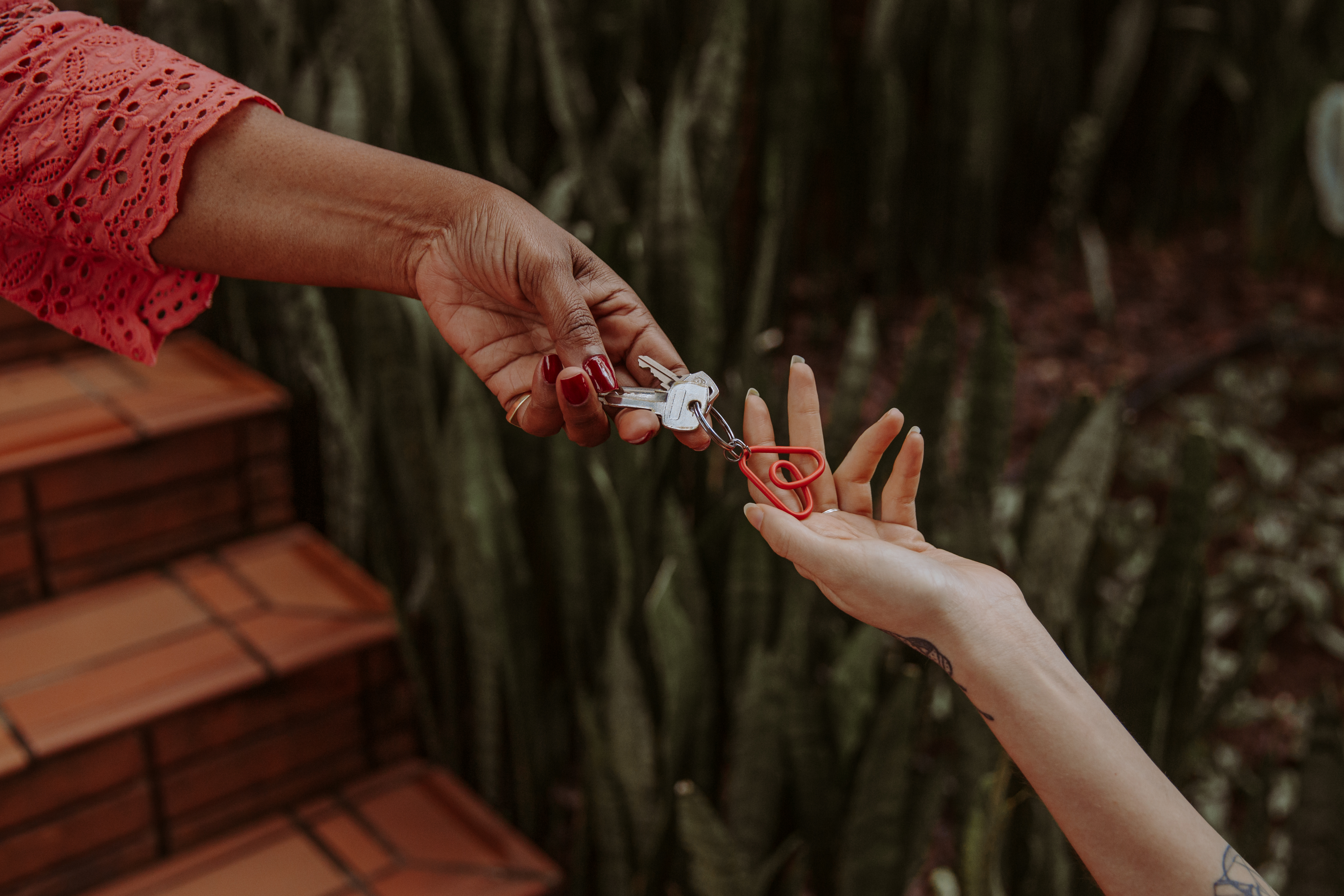 Mano entregando una llave con el logo de Airbnb a otra mano