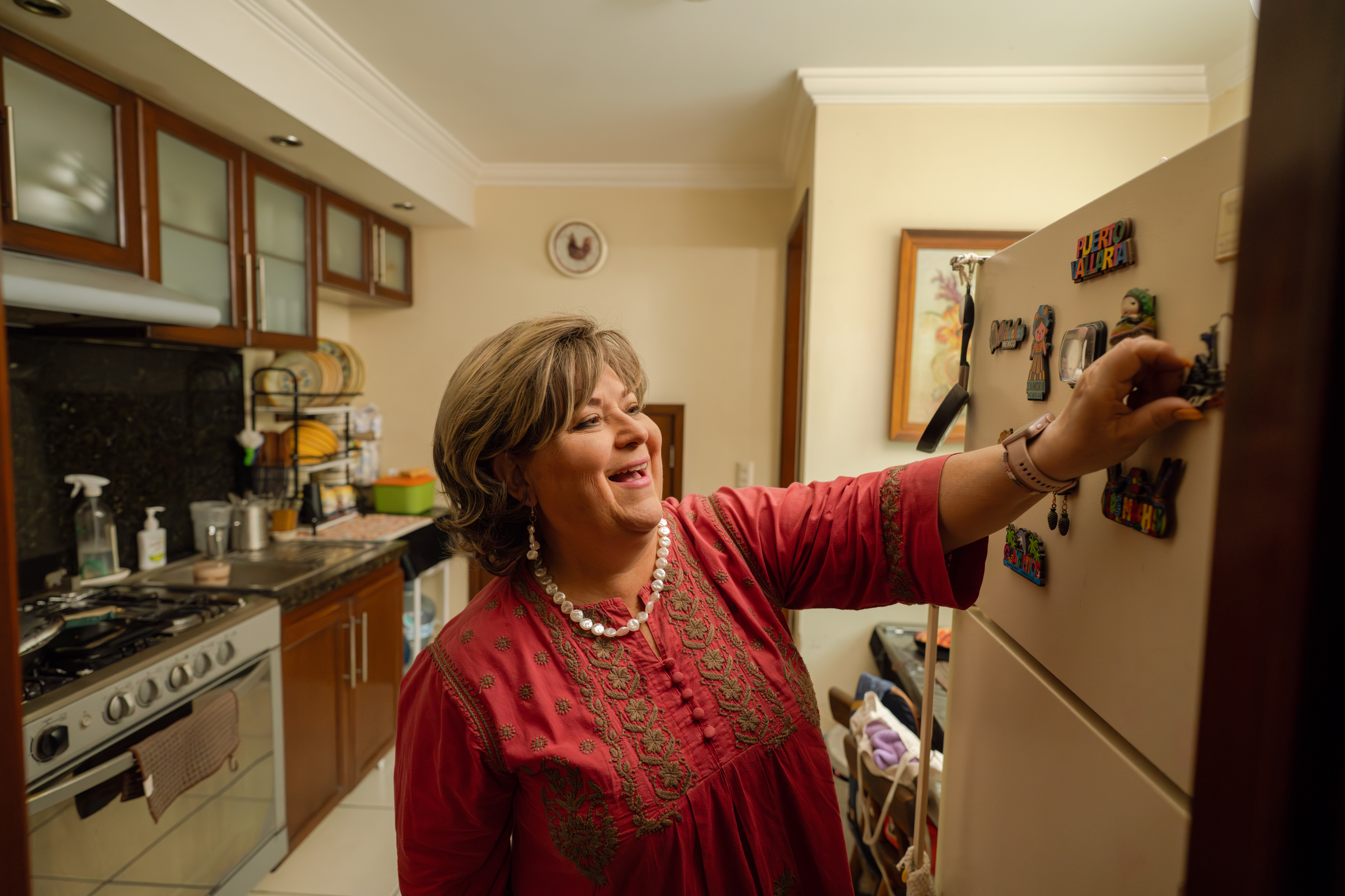 Mujer en la cocina colocando un imán en la nevera