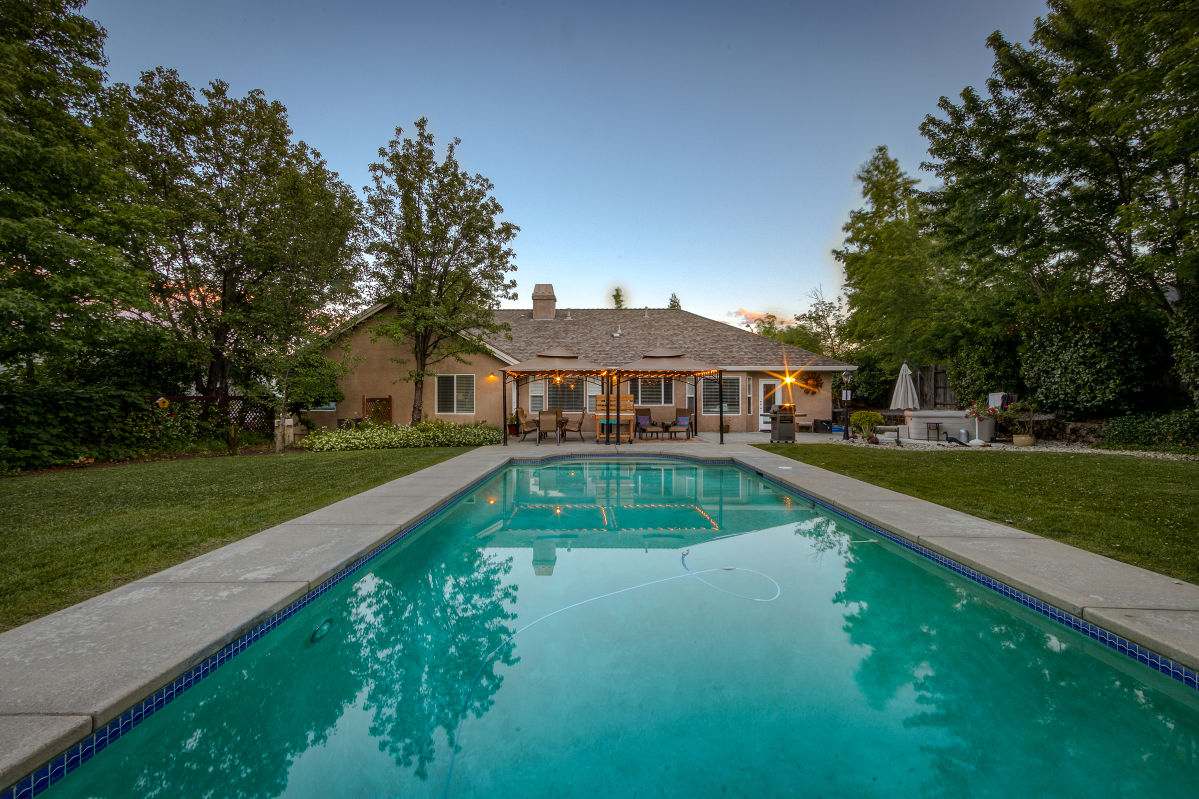 Terracotta house with a large pool in front of it.