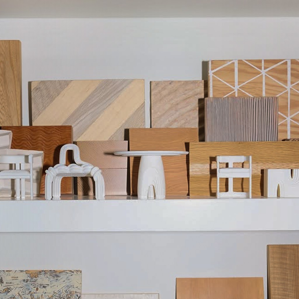 A neatly arranged shelf displaying assorted wooden samples, tiles, and textured fabric swatches in neutral tones, showcasing interior design materials and finishes.